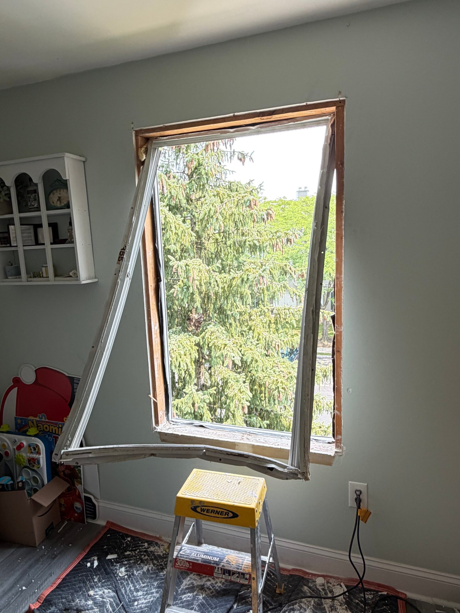 The original window assembly being removed from the first opening.