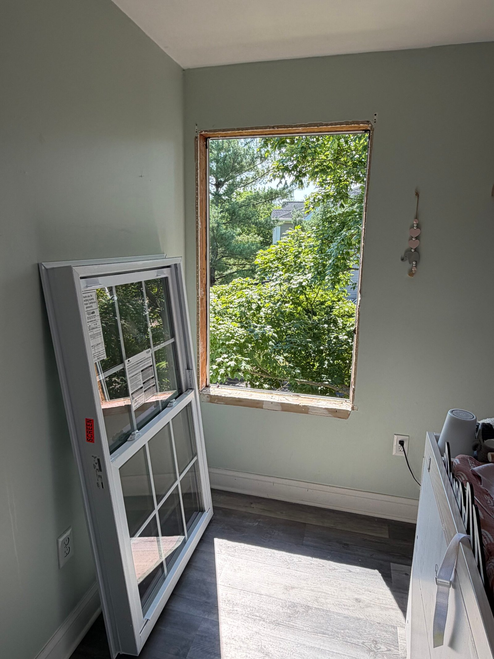 The second window opening exposed, with a window assembly standing inside the room.
