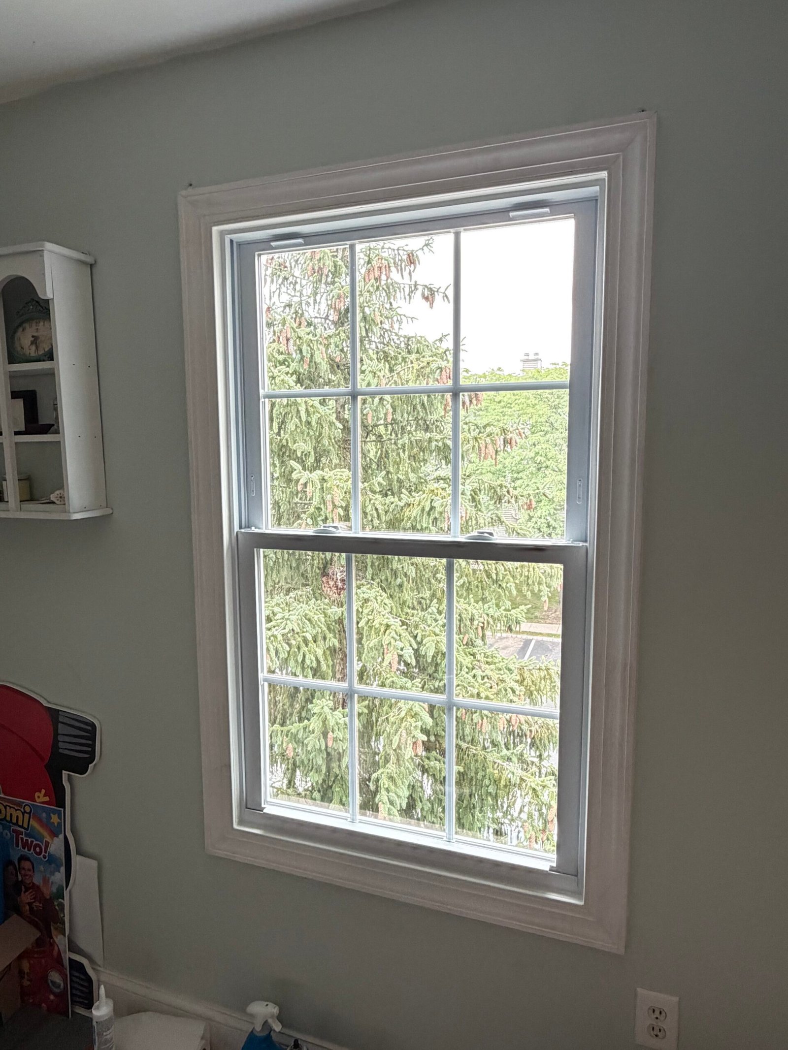 After: the first replacement window framed with finished white interior trim.