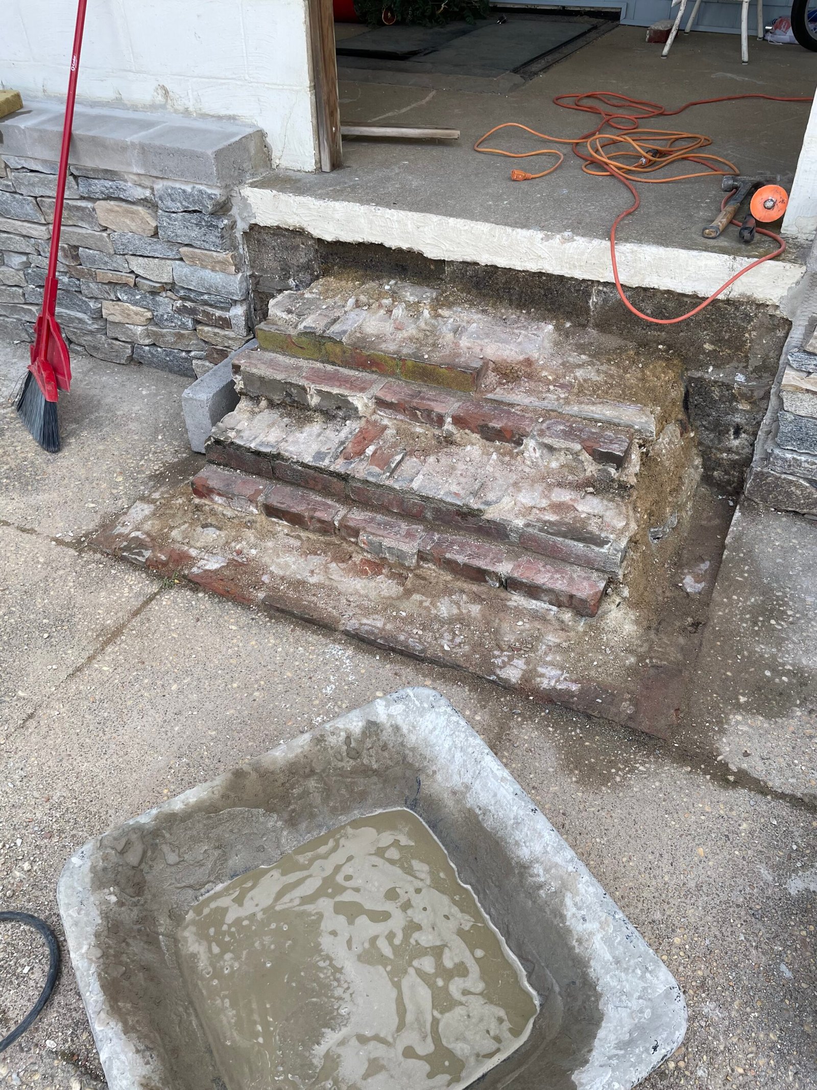 The exposed brick stair base after removal of the old visible step finish.