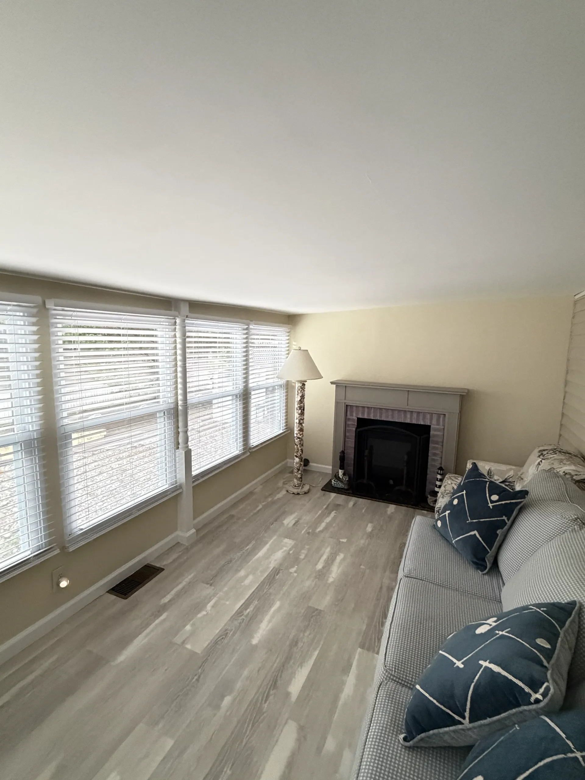 After: warm neutral walls and white window details in the finished seating area beside the fireplace.