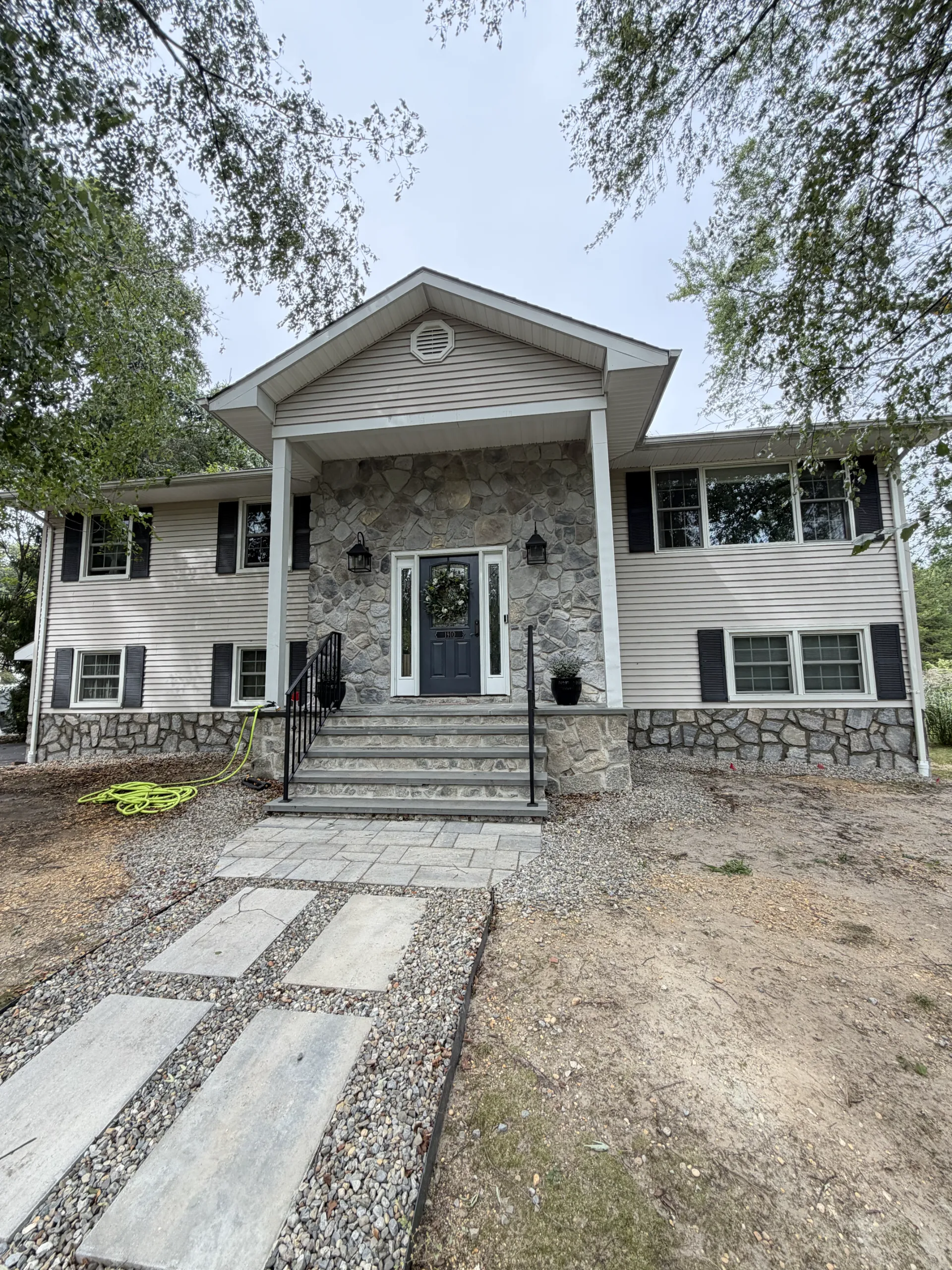 Overall view: the stone-faced foundation connects visually with the existing entrance masonry.