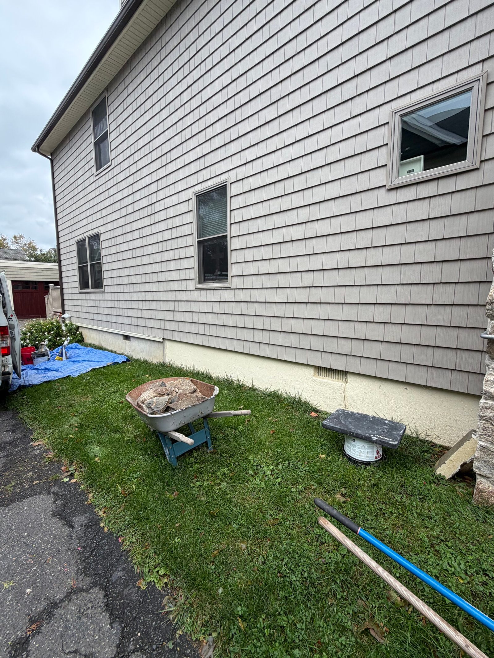 Before: the plain foundation band beneath the gray shingle-style siding.