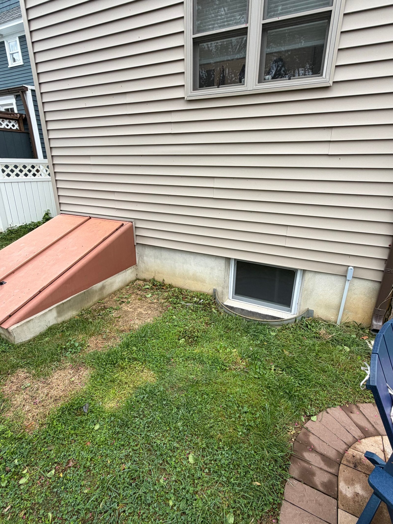 Before: the exposed foundation around the basement window and cellar entrance.