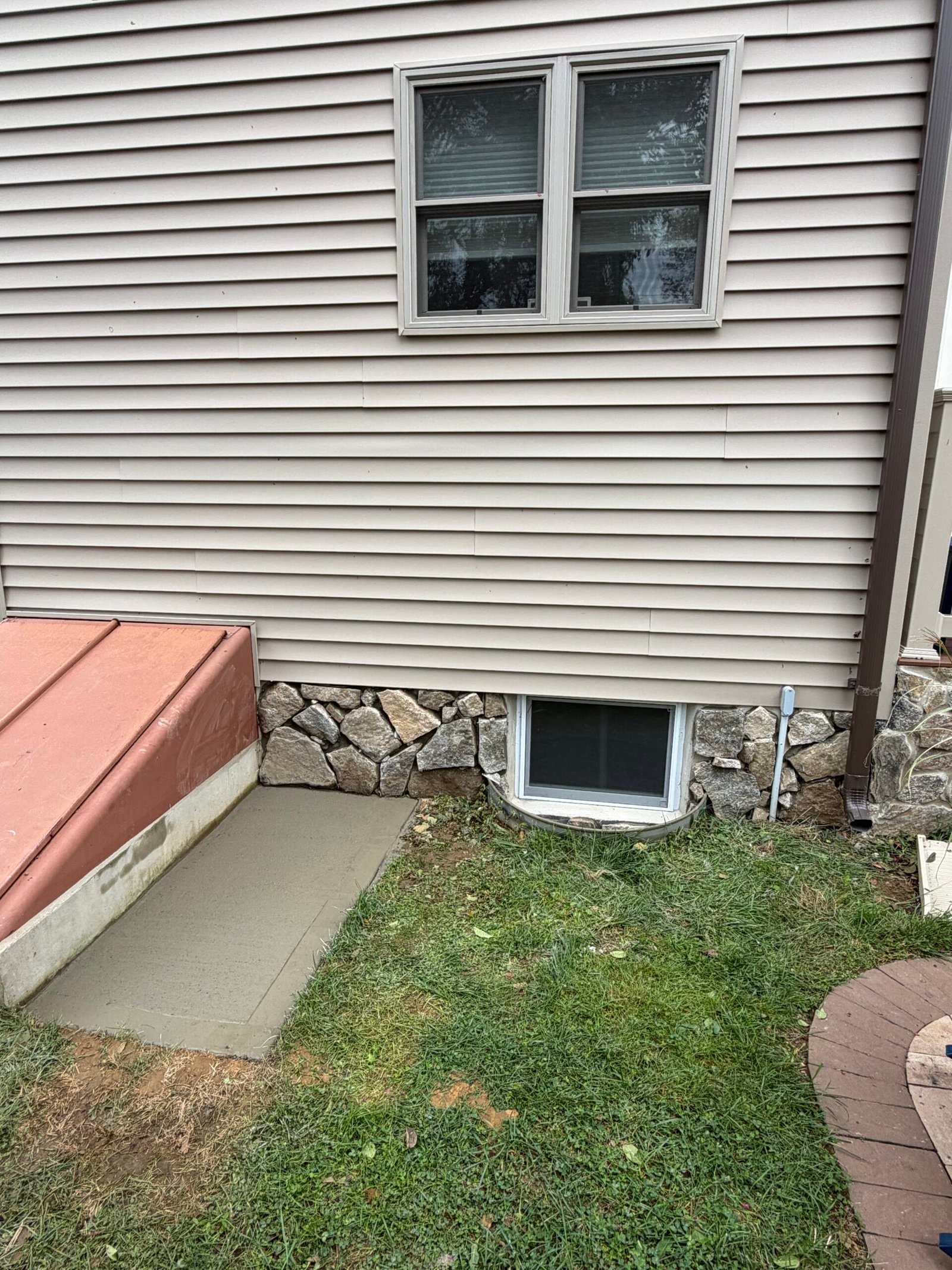 Stone shapes fitted around the basement window, entrance and existing utility details.