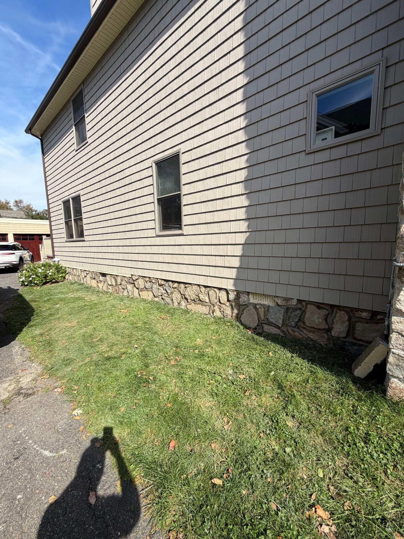 After: the completed stone-faced foundation and its mortar-joint pattern along the wall.