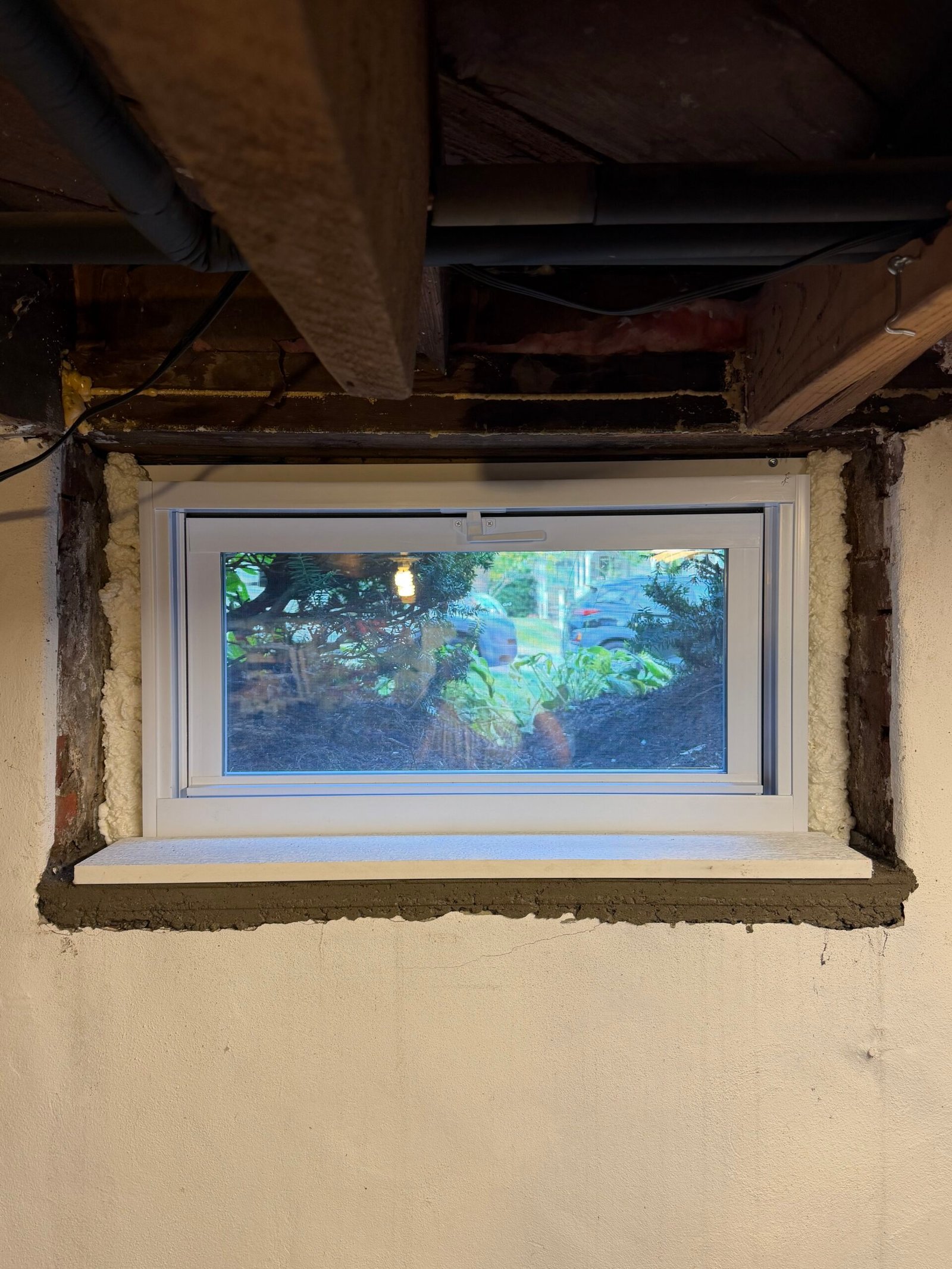 The new white-framed window in place, with local masonry-edge finishing visible around it.