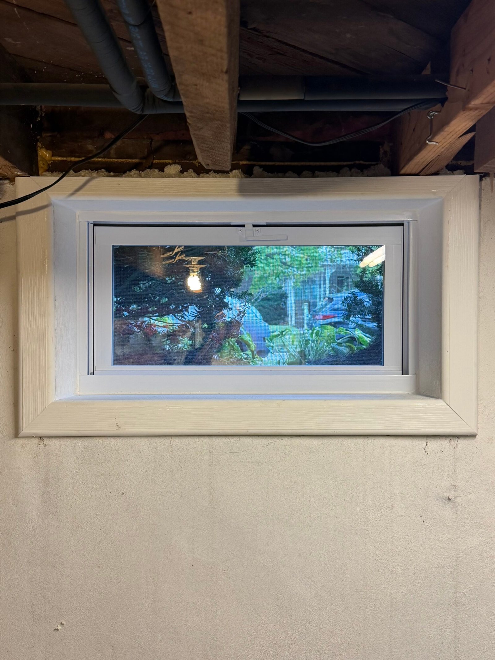 After: the replacement basement window with a completed white interior border.