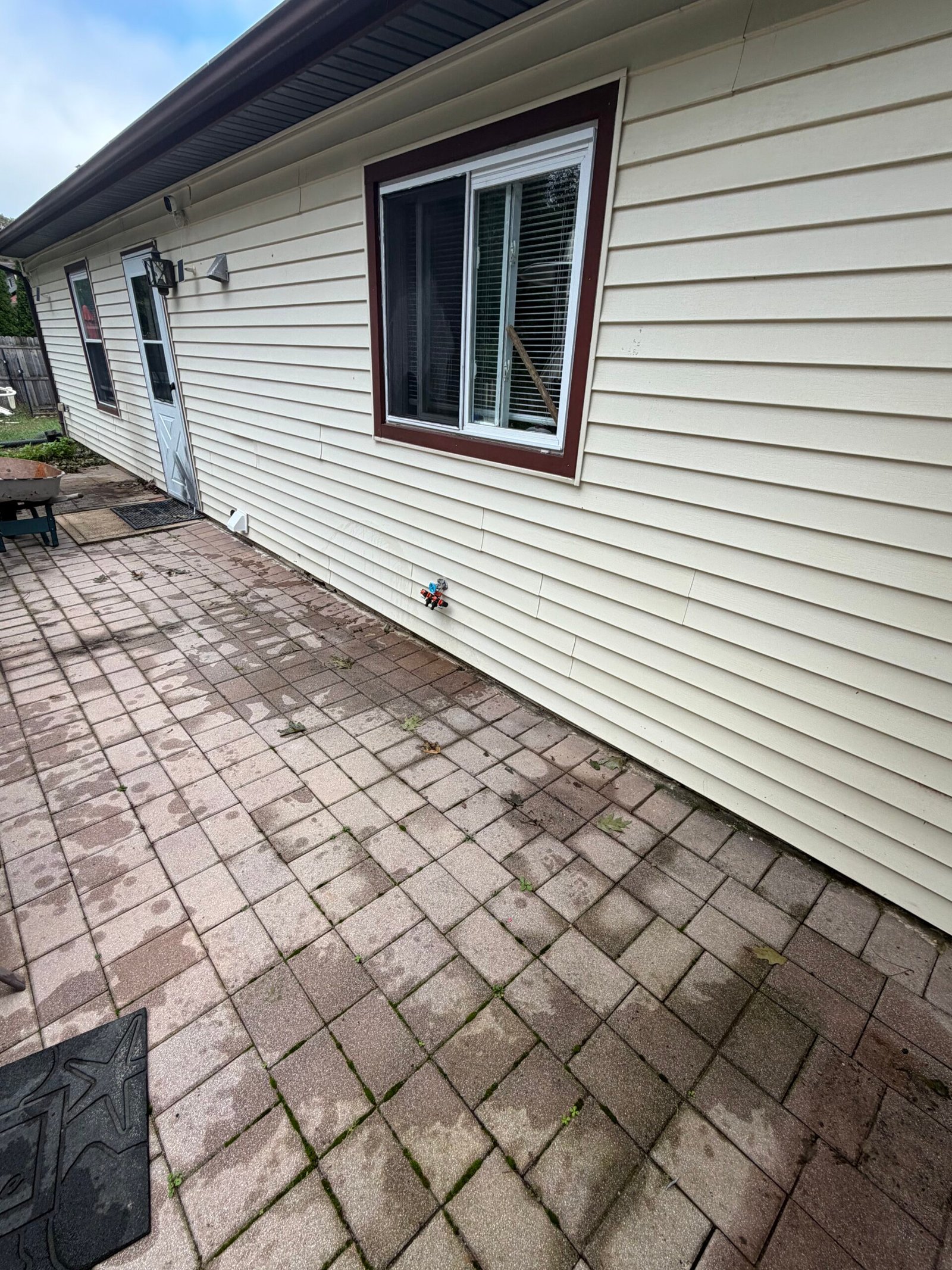 The original paver surface running along the wall beneath the windows.