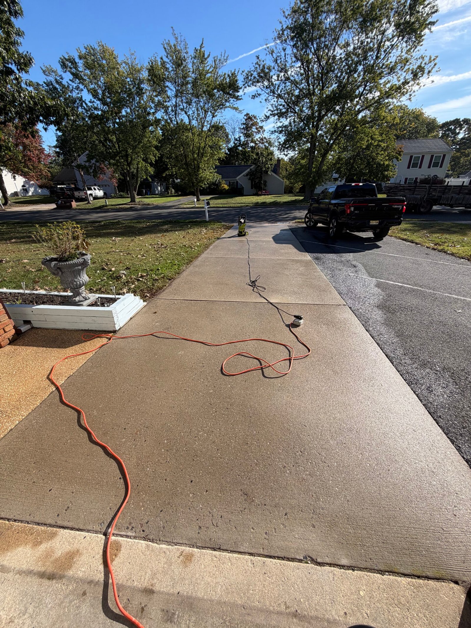 Before: the driveway concrete, existing joints and adjoining asphalt viewed from the house.