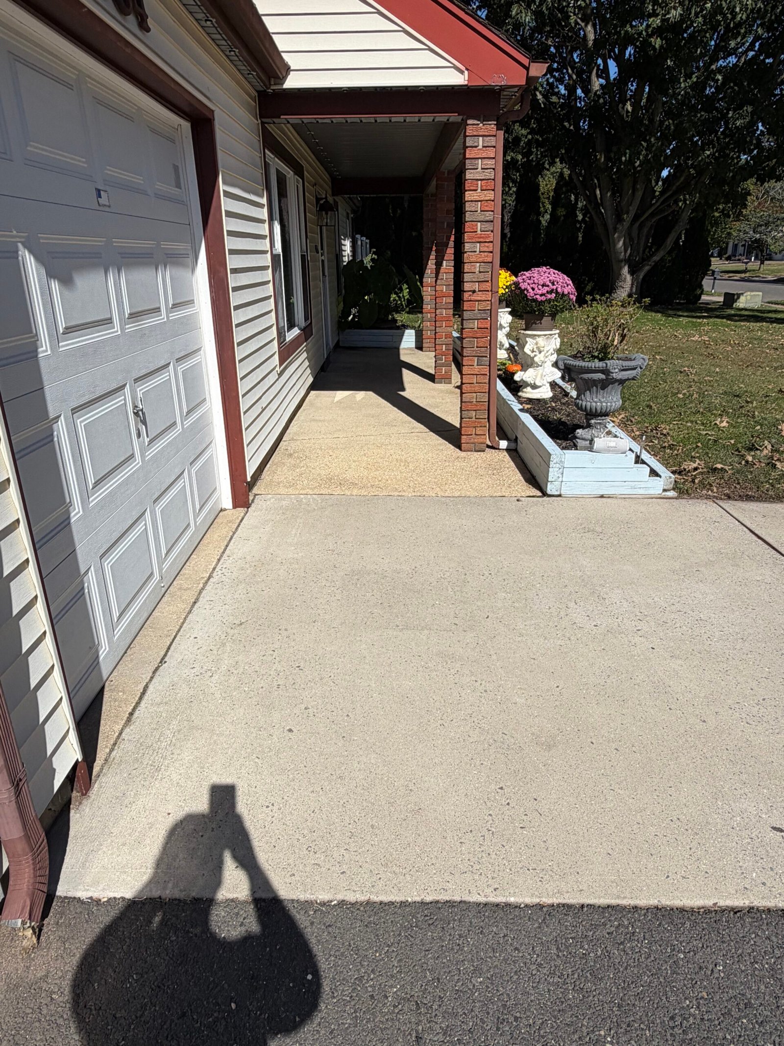 The lighter concrete surface beside the garage during preparation for the new finish.