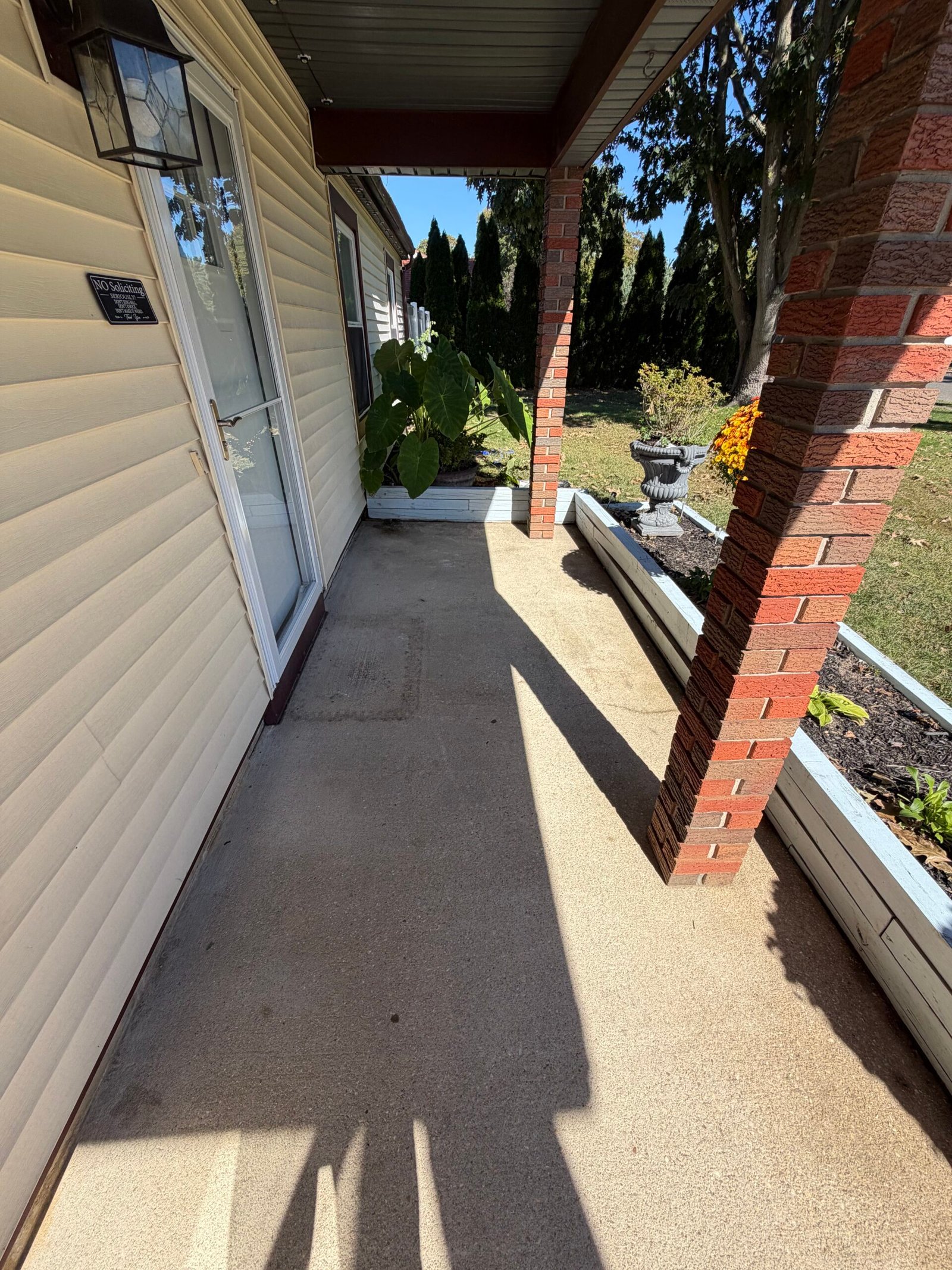 The entry floor, brick column and planter edge during preparation.