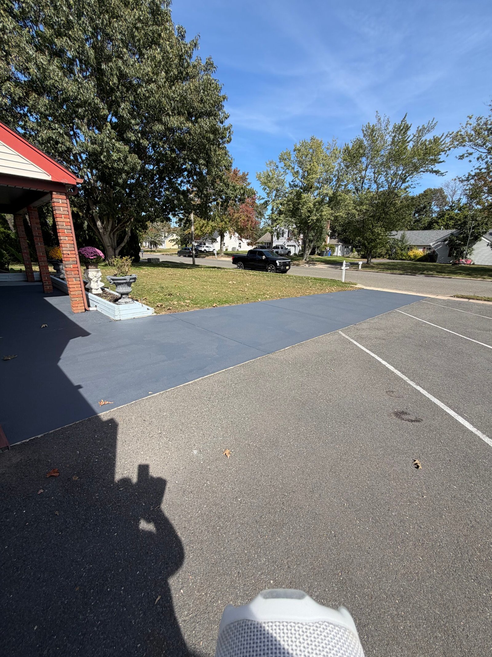 After: the gray-coated driveway strip meeting the garage and adjoining asphalt.