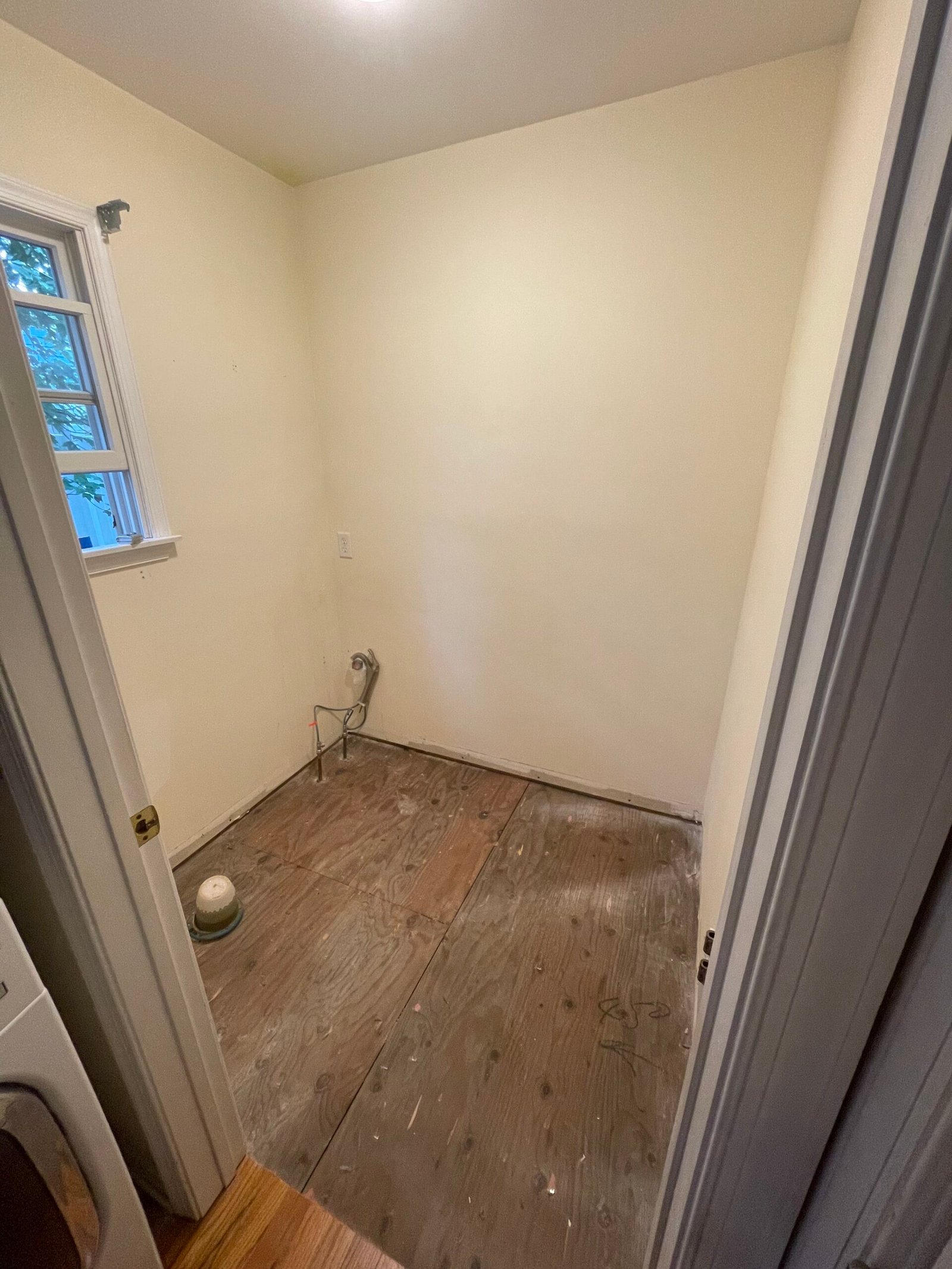 Before the new finishes: bare walls, an exposed subfloor and existing plumbing locations.