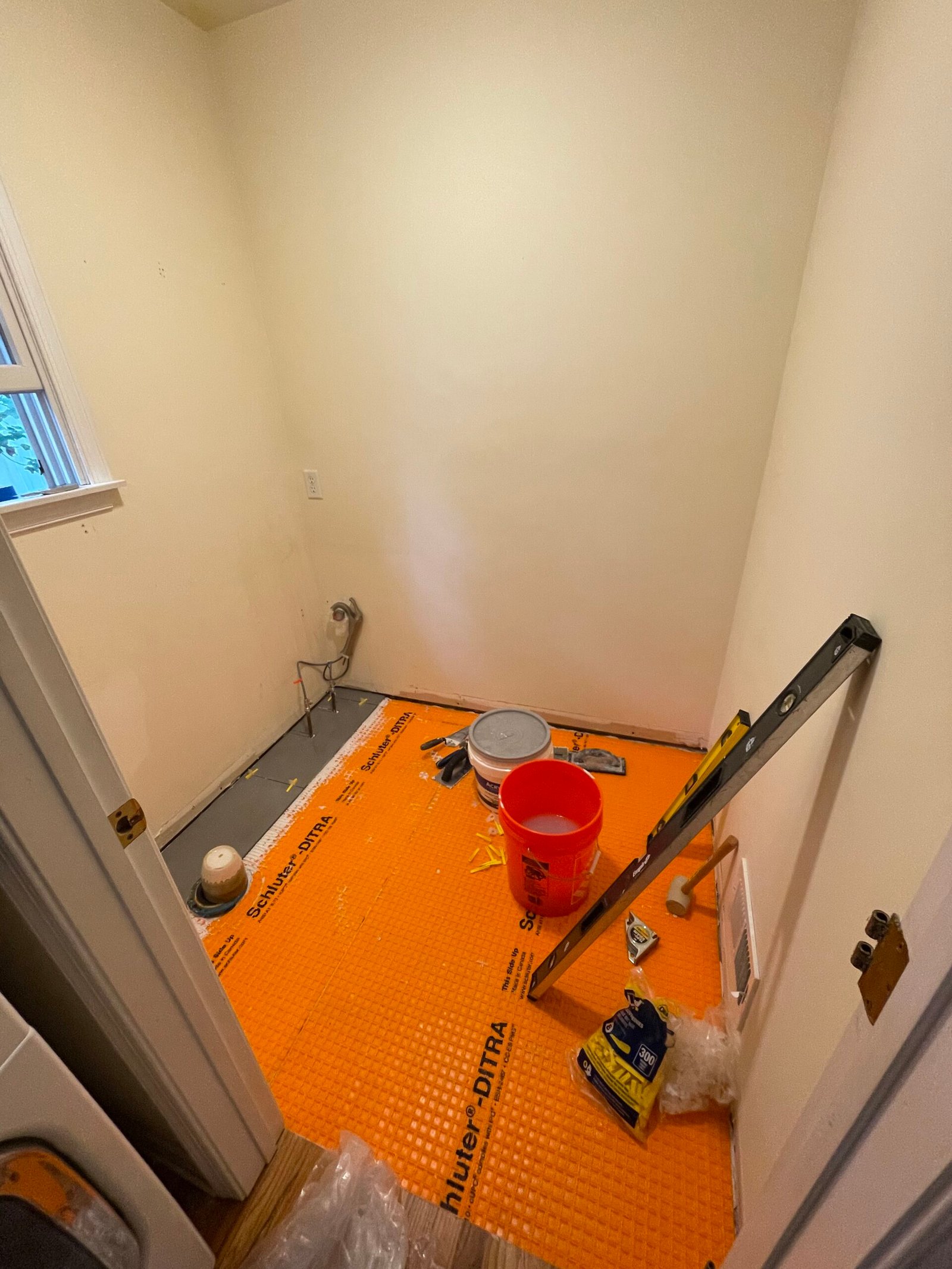Orange floor underlayment installed ahead of the new tile.