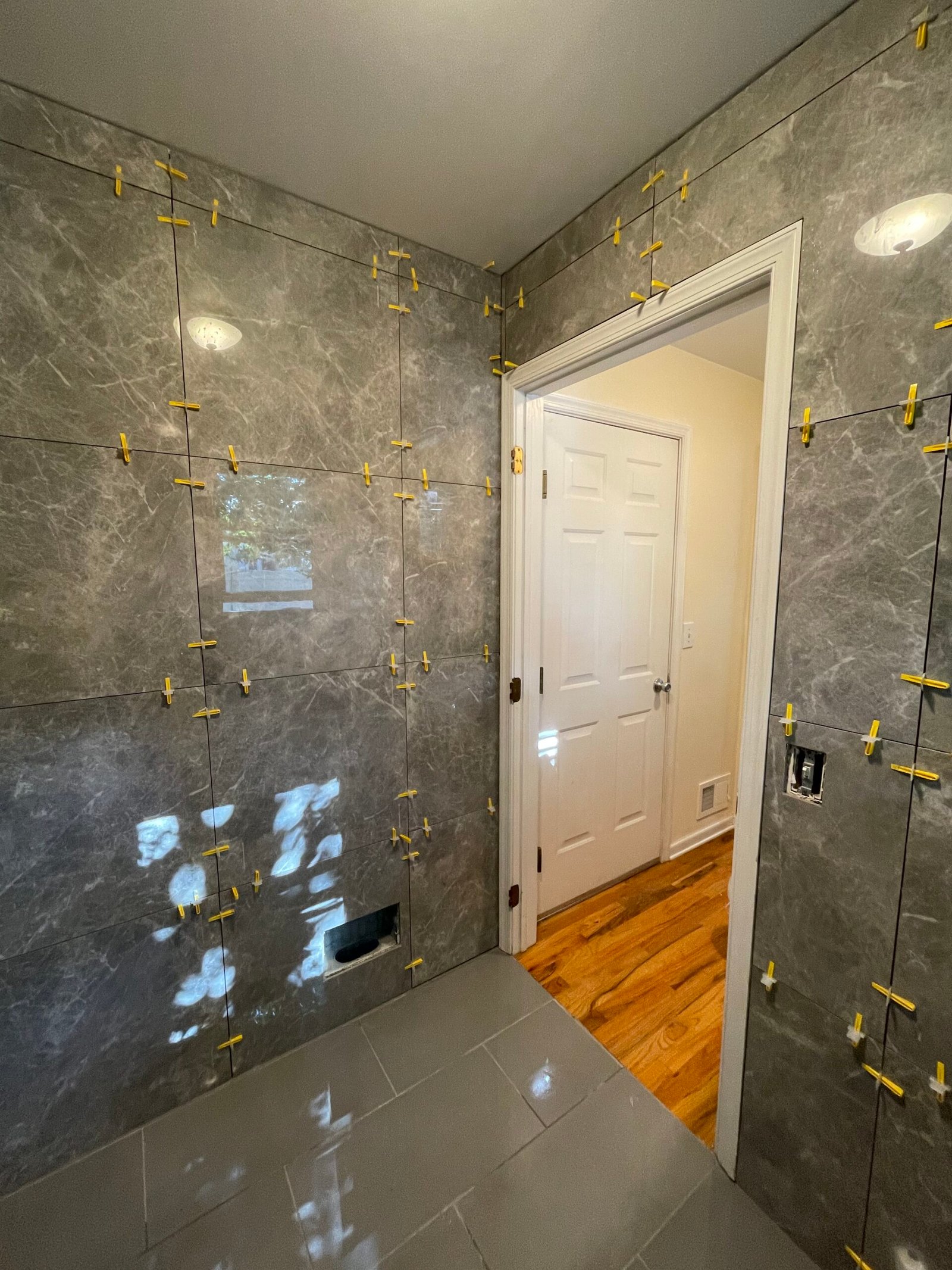 Detailed tile cuts and alignment around the bathroom doorway.
