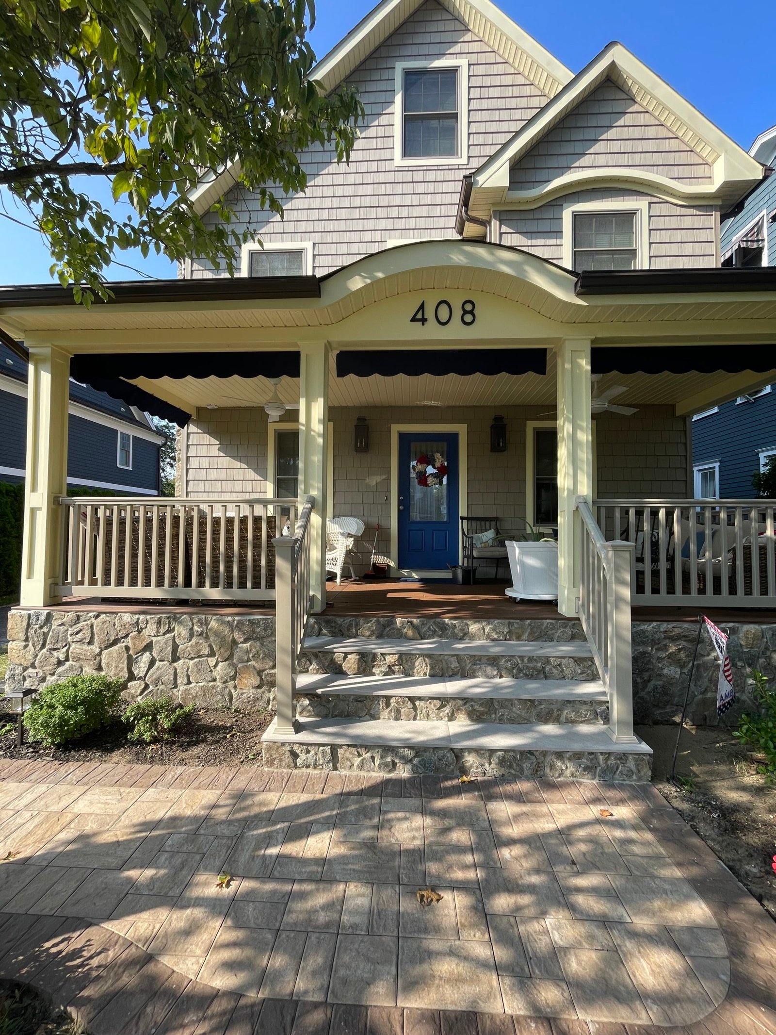 After: the completed front entrance with gray stair treads, stone risers and a coordinated stone base.