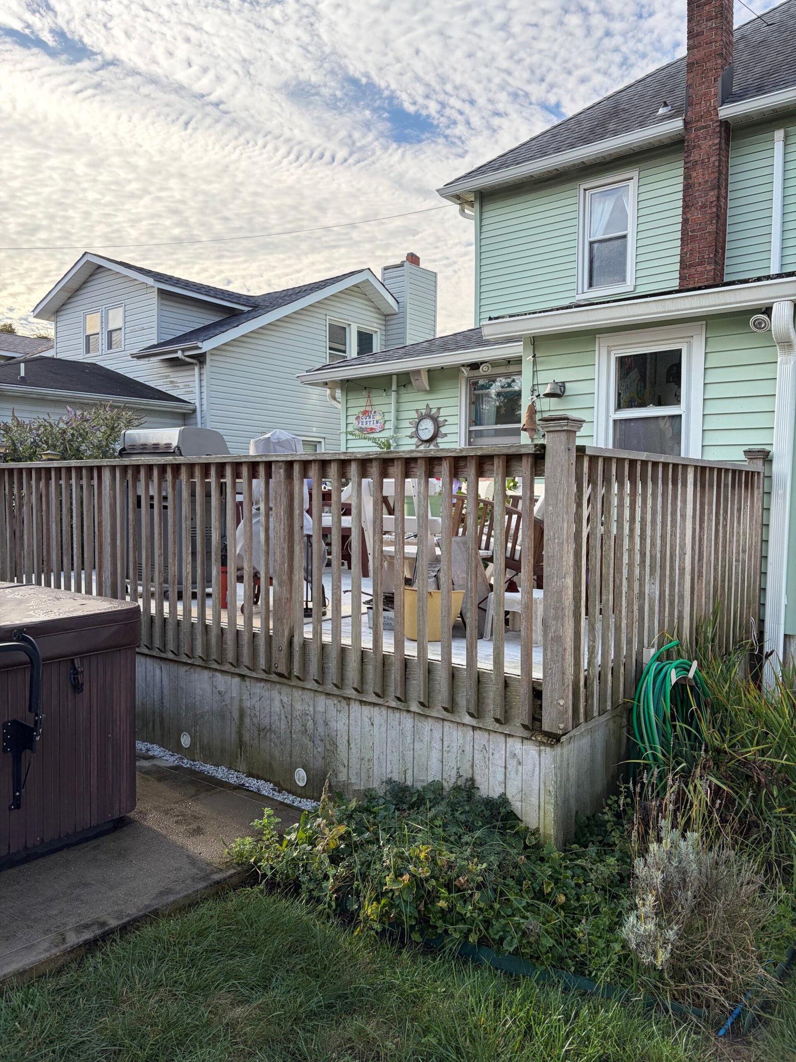Before: weathered timber railings along the garden side of the deck.