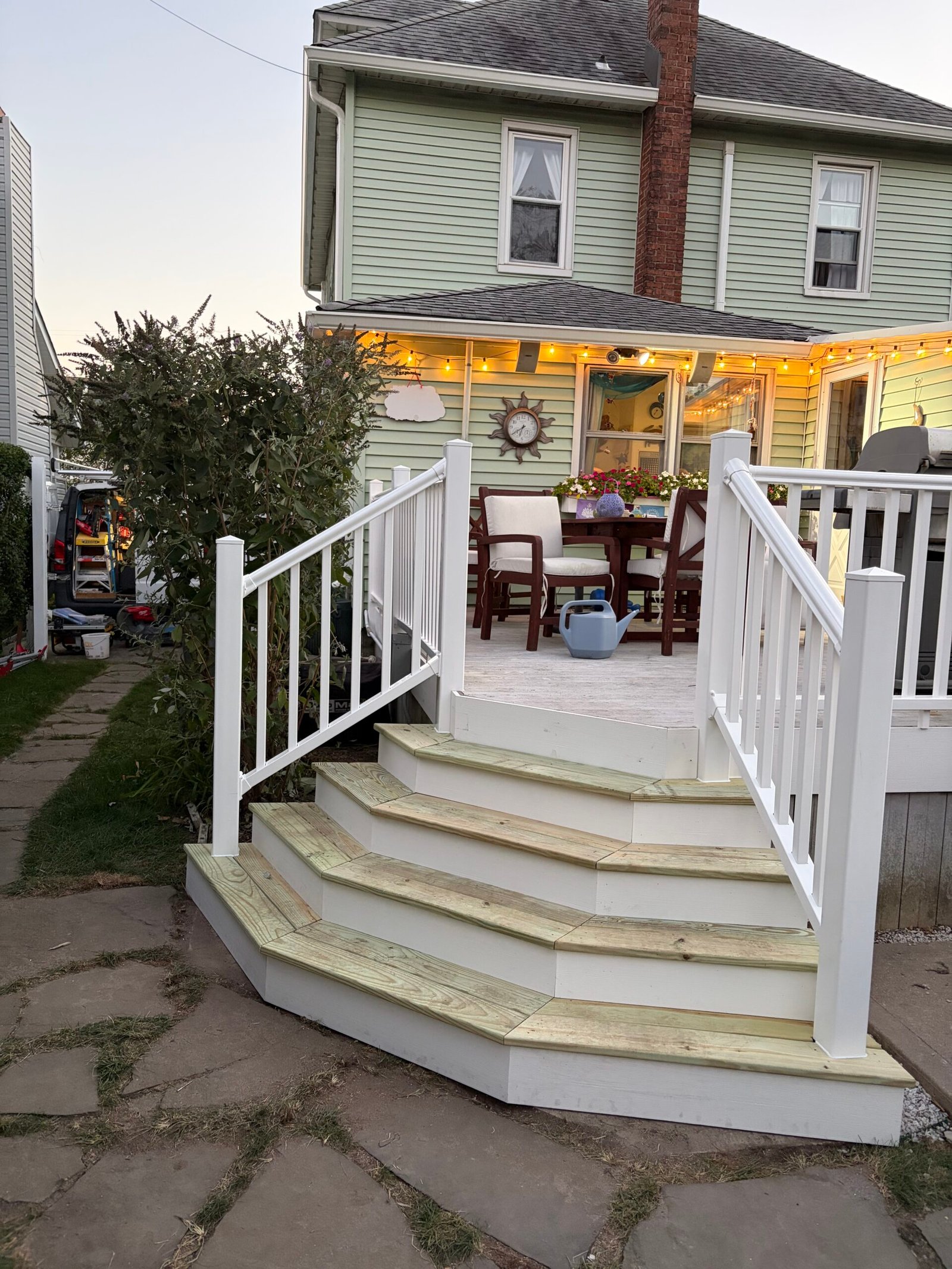 After: the completed stair run and white railings connecting the deck to the path.