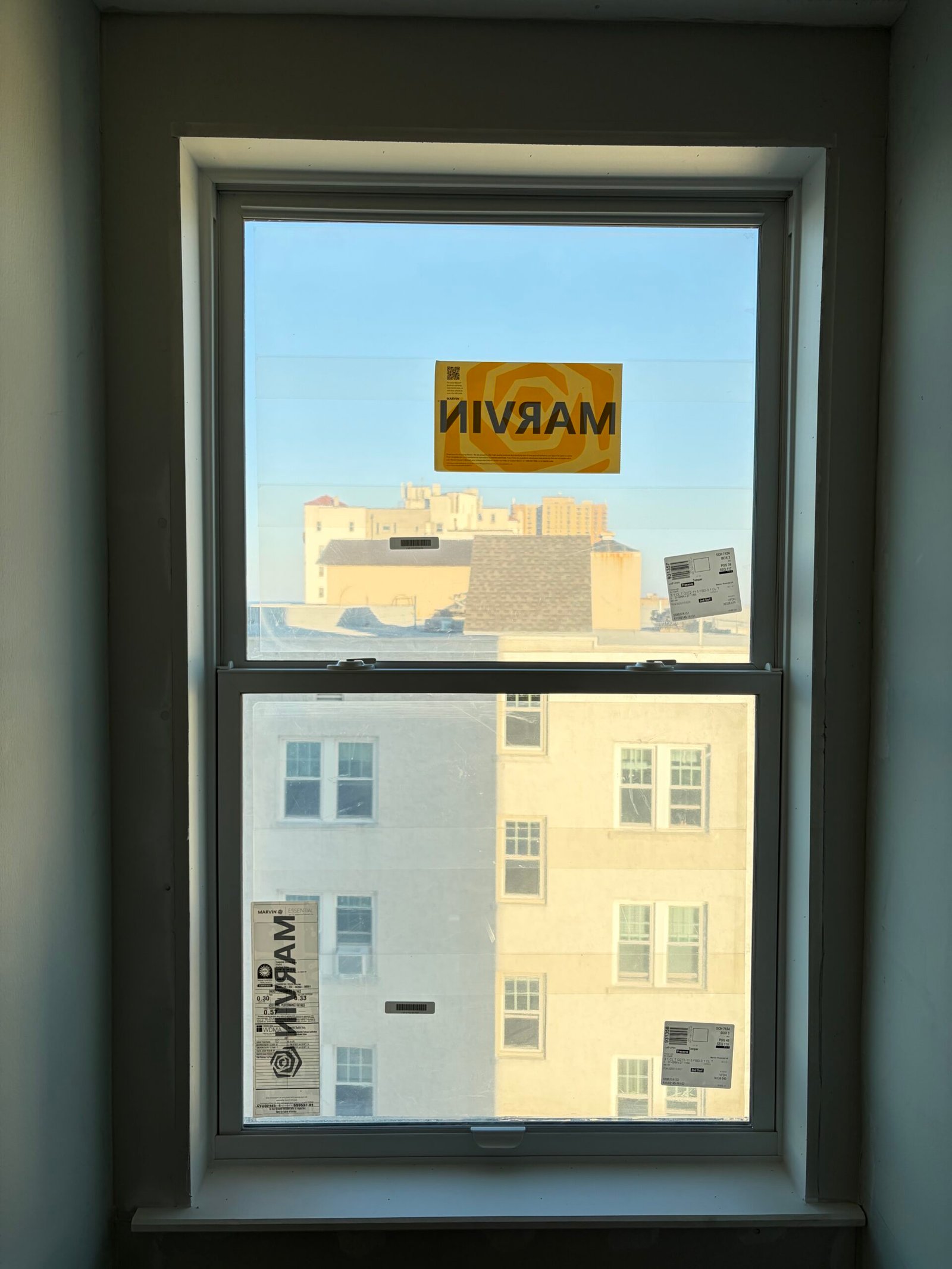 The replacement window installed, with product labels still on the glass.