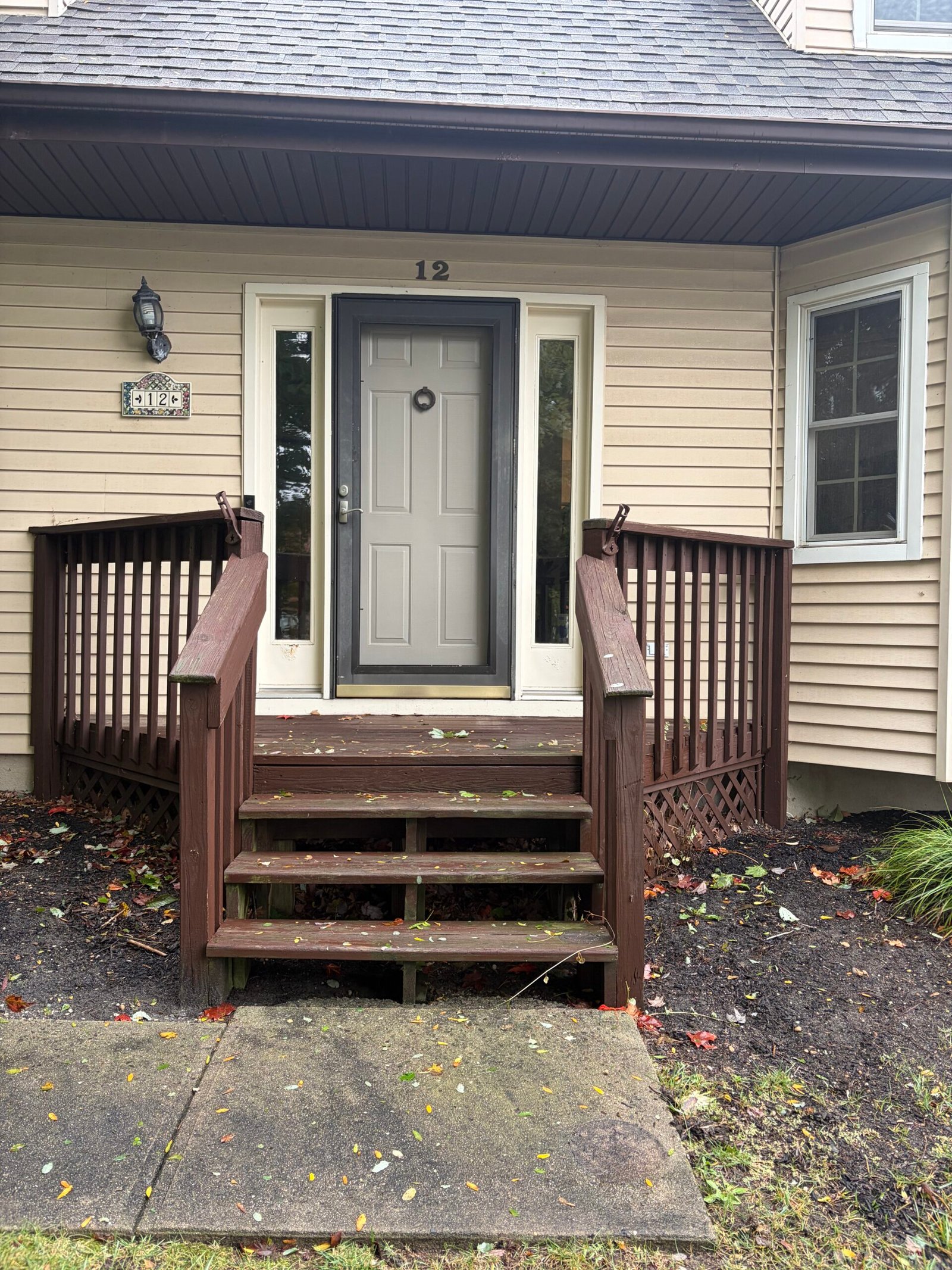 Front view of the original porch, narrow stair opening and worn step surfaces.