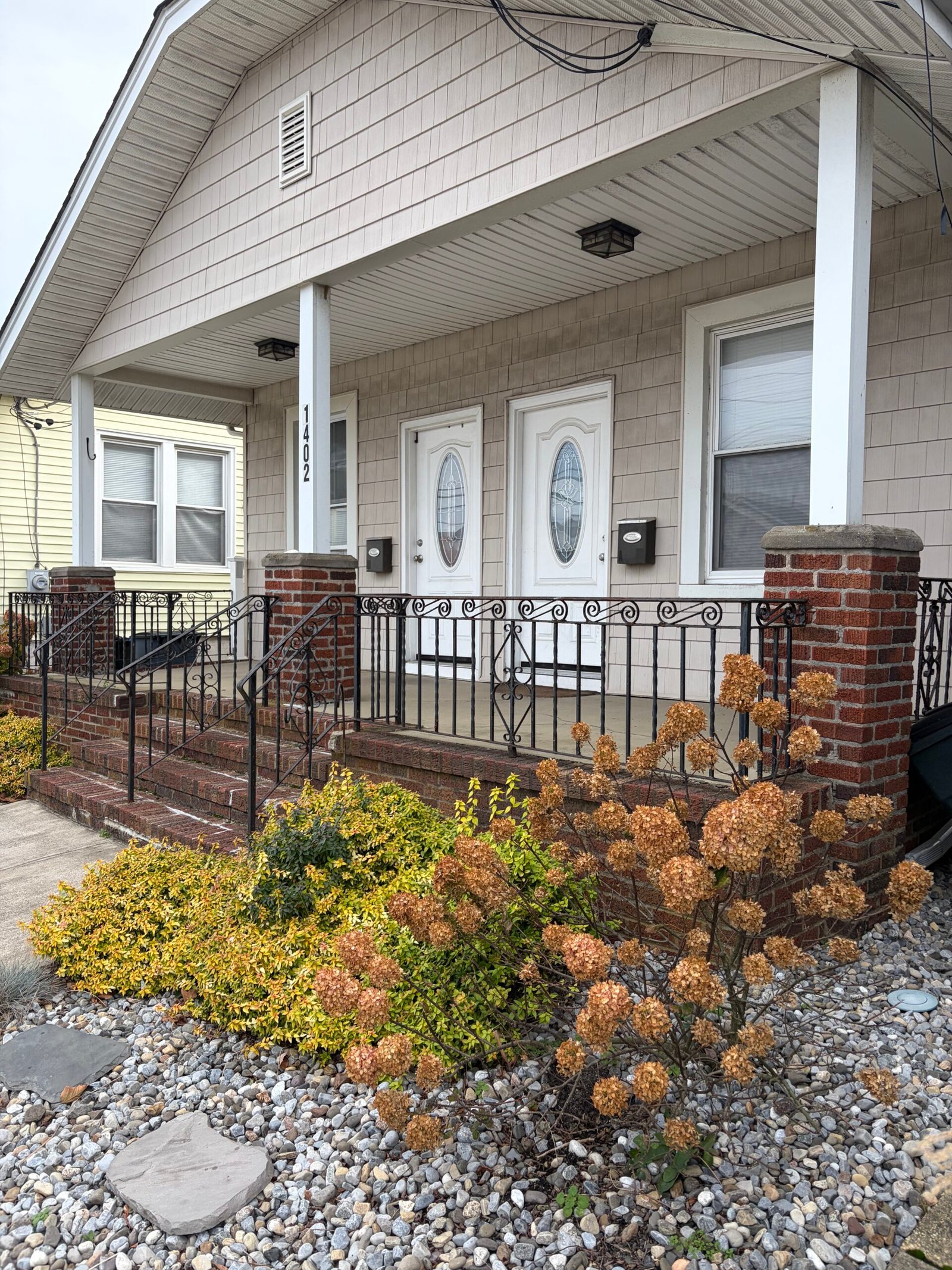 Before: the brick porch, entry steps and decorative black railings from the garden side.