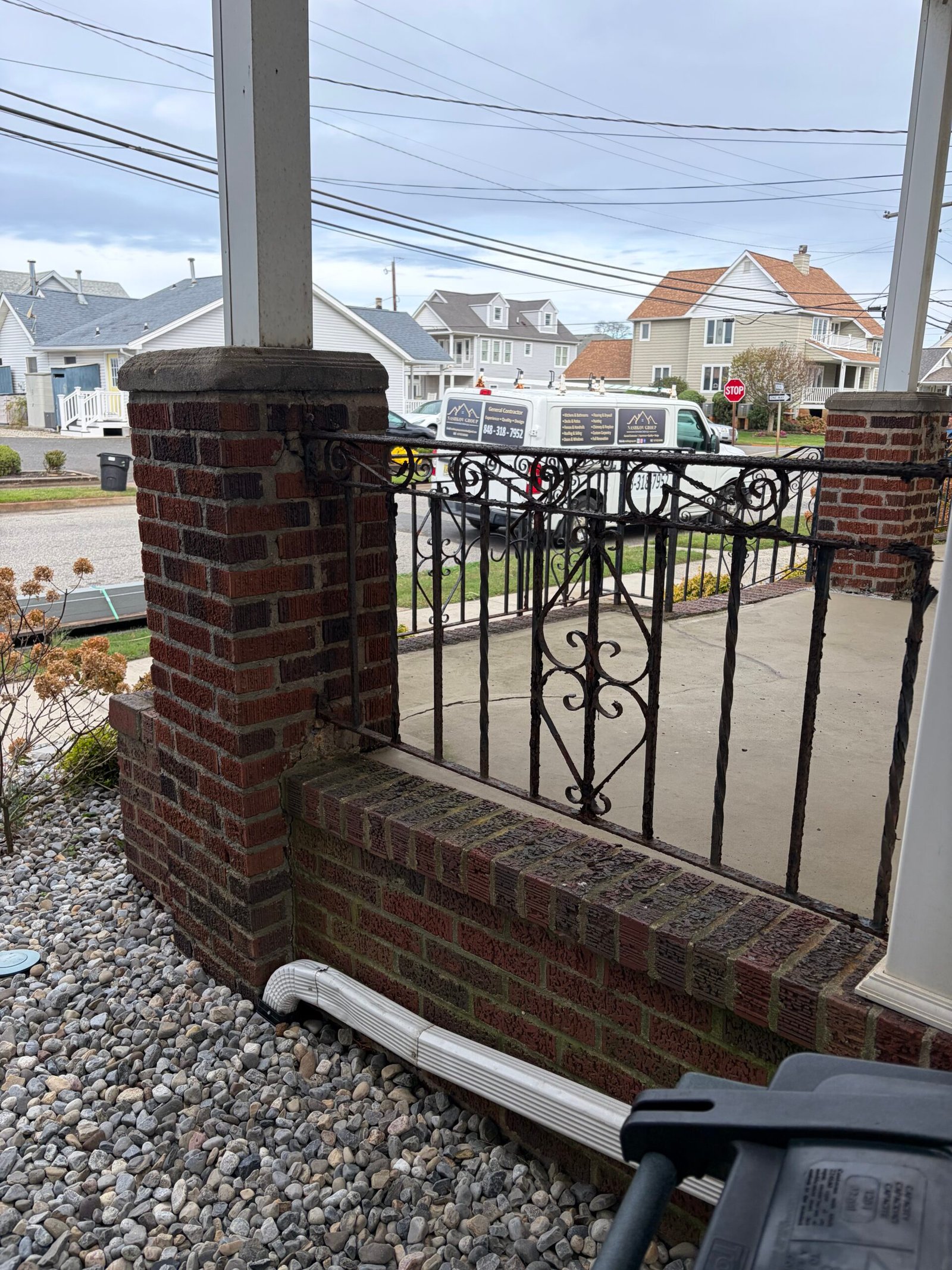 Before: a porch pier, brick base wall and existing decorative black railing.