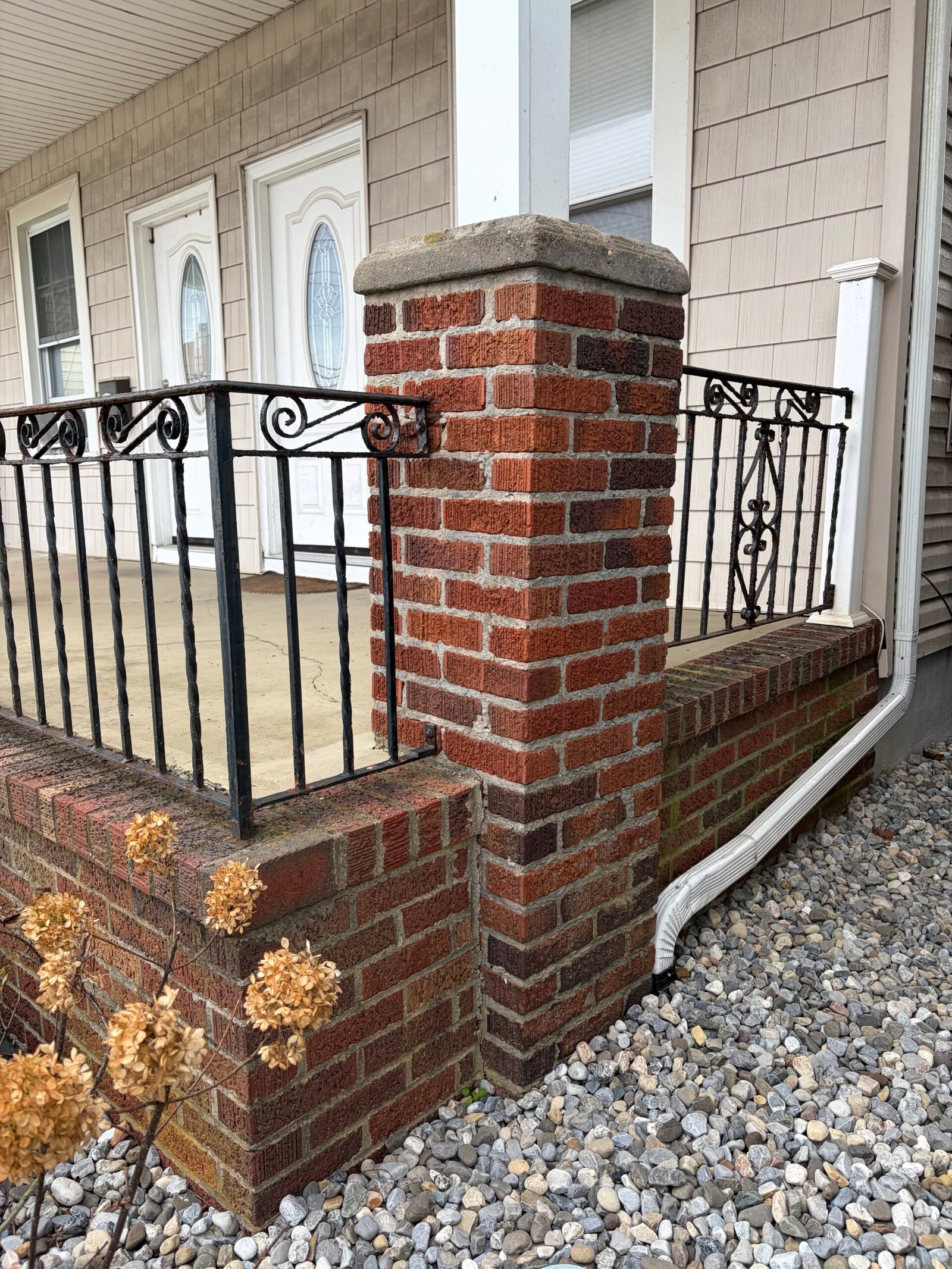 Before: the original red brickwork at the porch corner and adjoining railing.