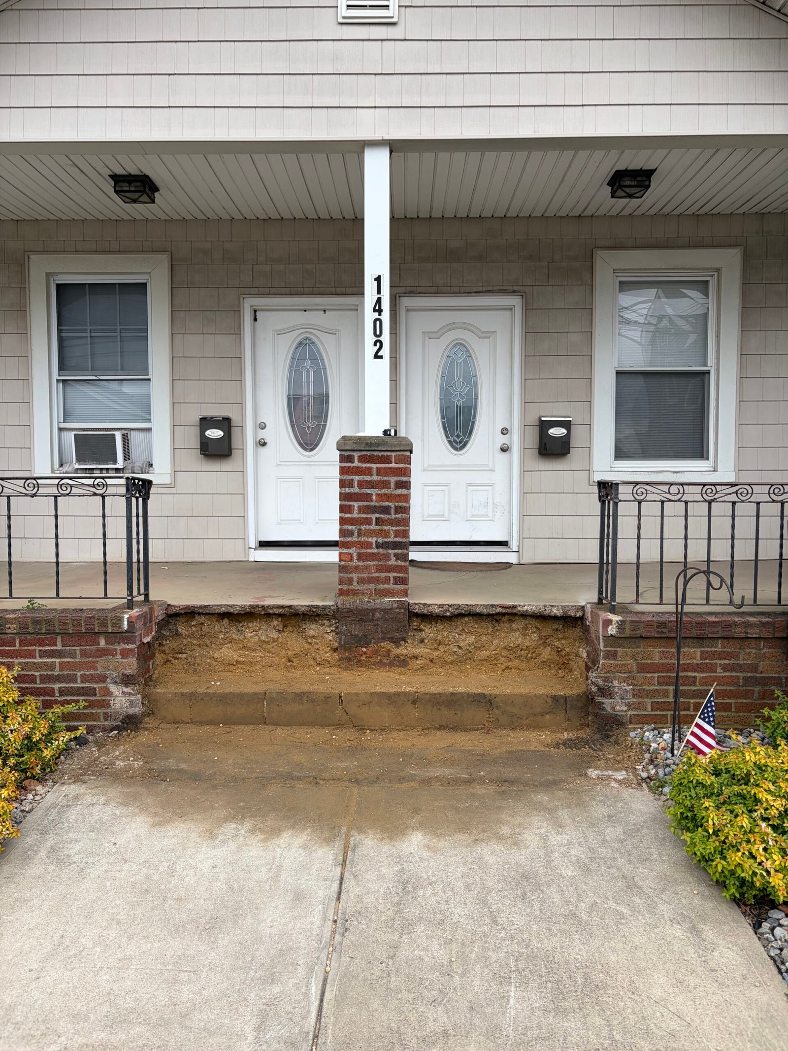 The former stair area opened and cleared in front of the retained porch landing.