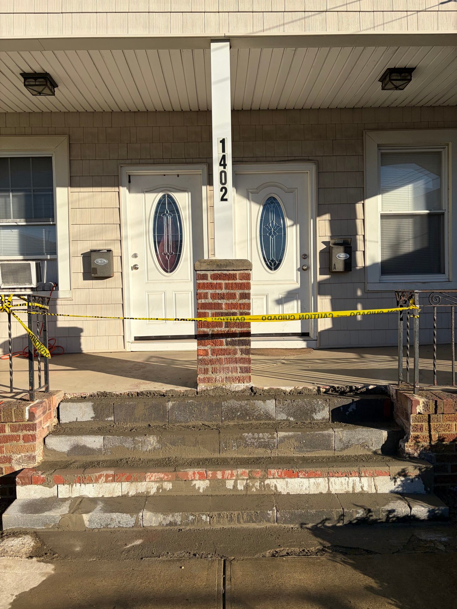 Gray treads in place while the stair masonry and adjoining landing edge are being repaired.