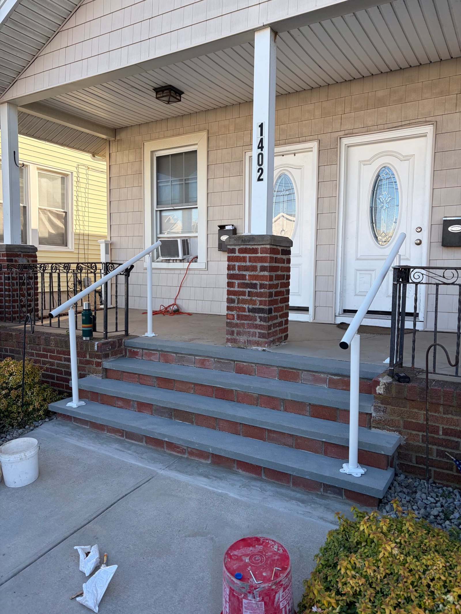 An angled view of the gray stair treads and new white handrails before the final masonry finish.