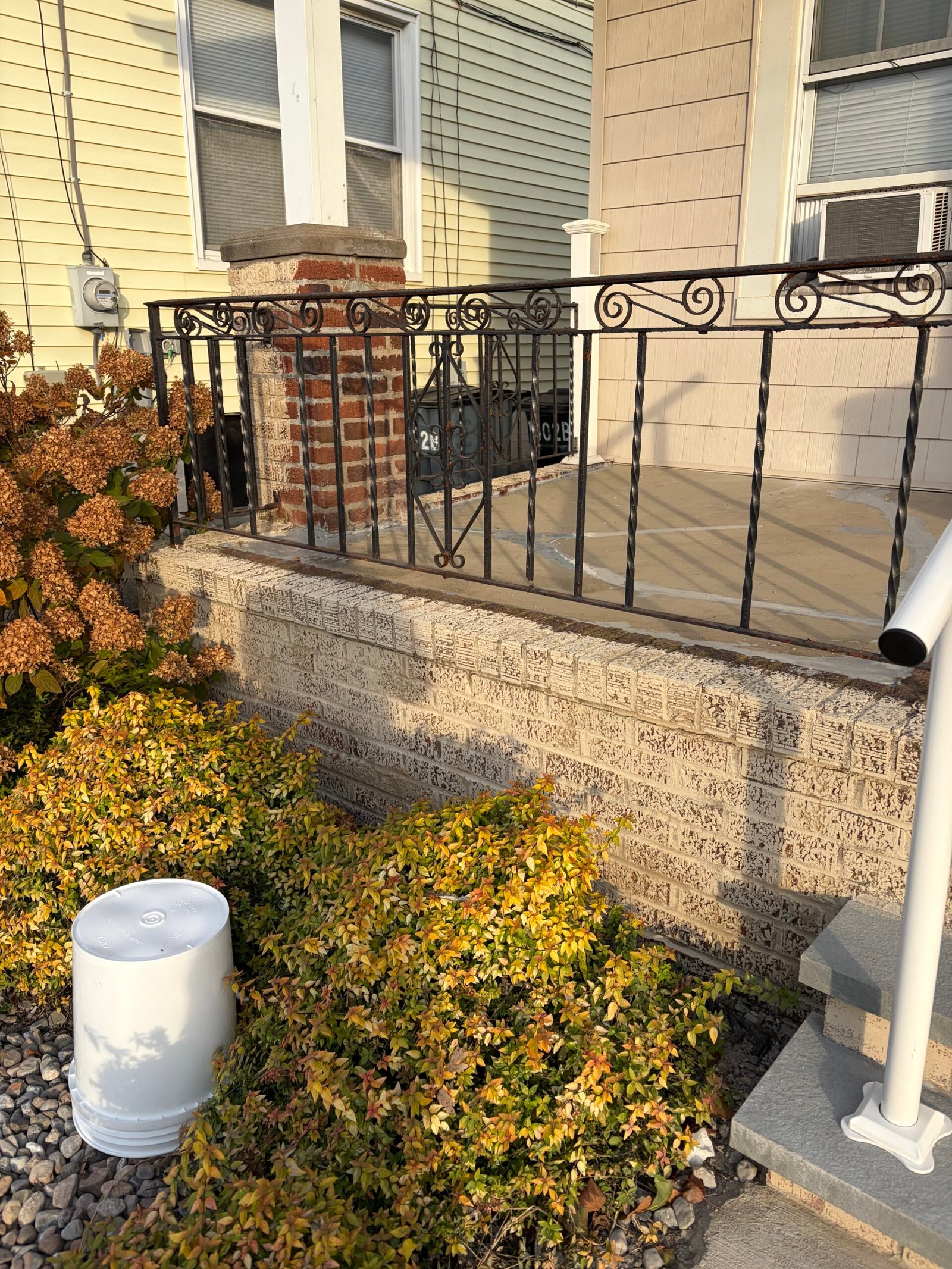 A light decorative finish progressing across the porch base, with the original brick texture still visible.