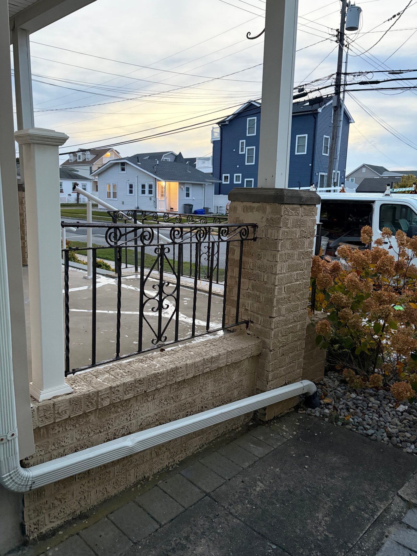 After: the light-finished side porch wall and pier above the paved side path.