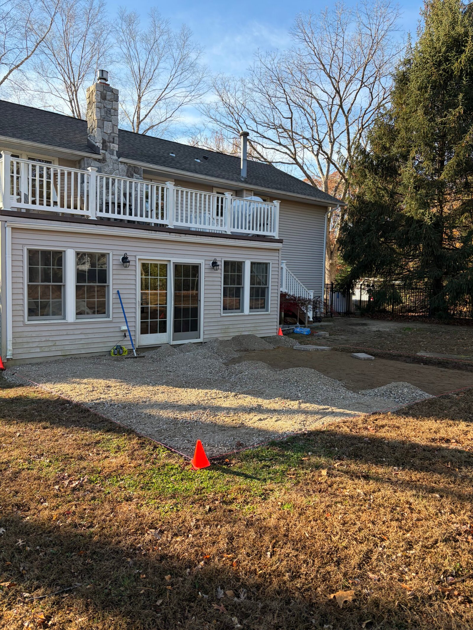 Base placement in progress, with piles of aggregate and the perimeter line visible.