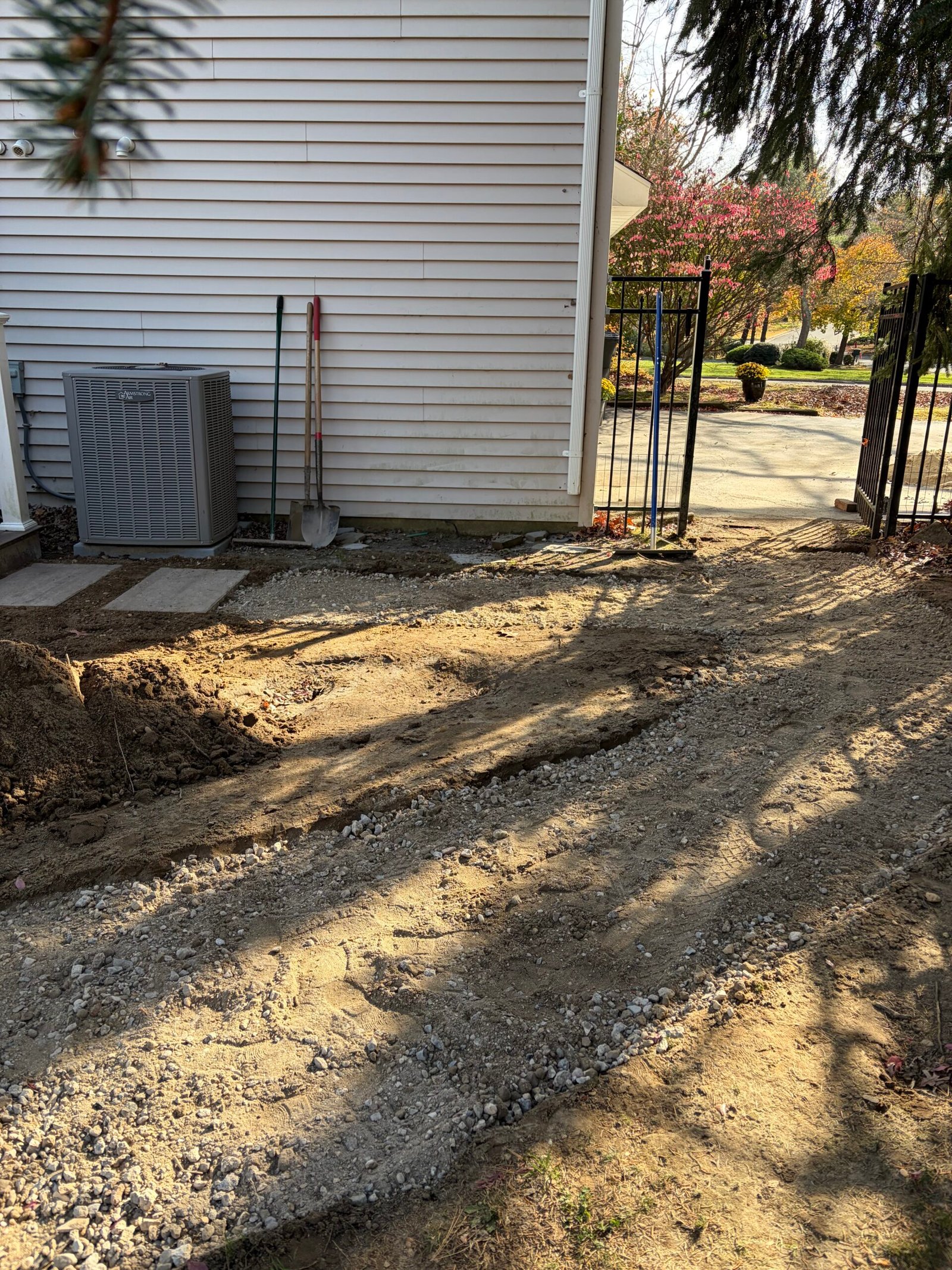 The prepared route bending past the side of the house toward the gate.