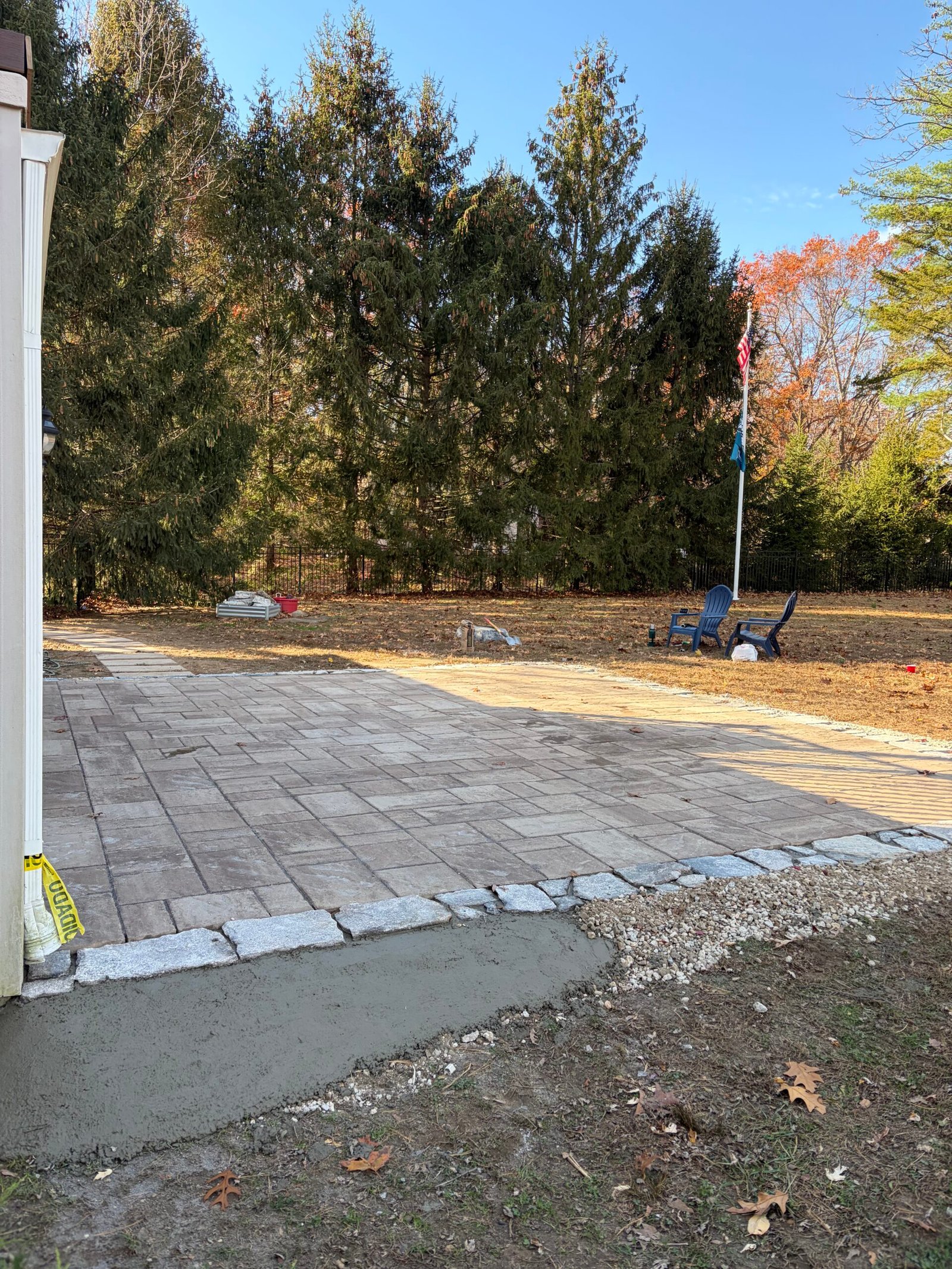 Rough stone edging installed beside the pavers, with support visible along the outside.