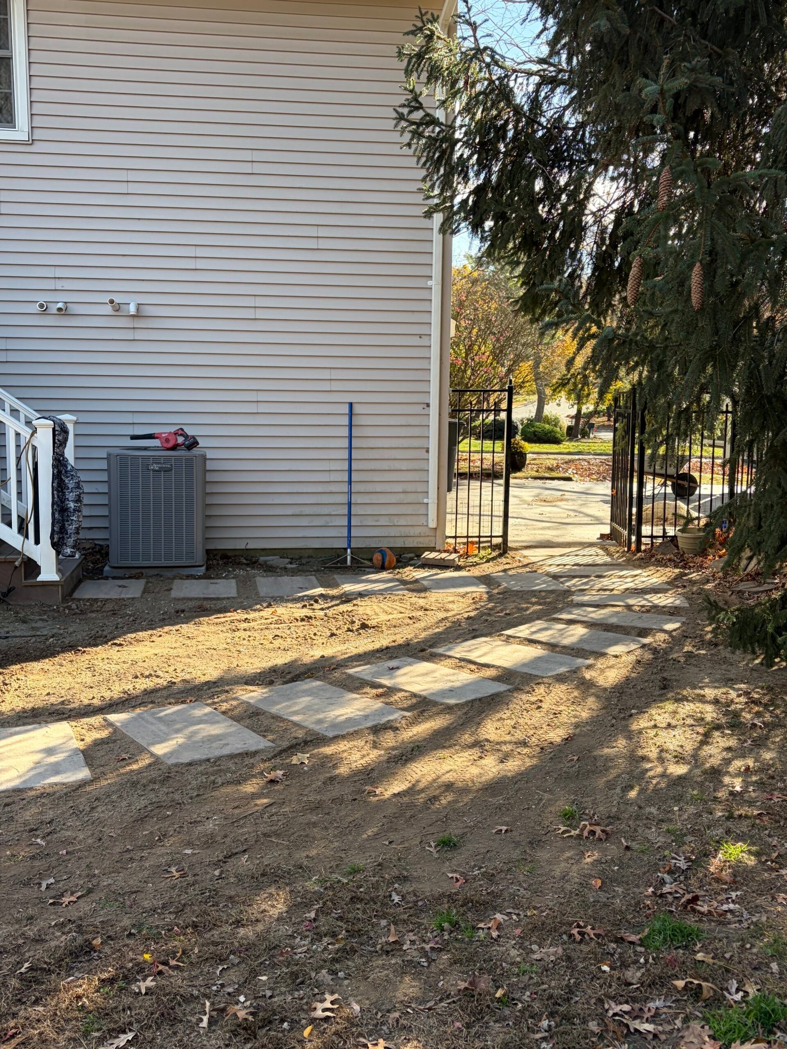 After: spaced square stepping stones leading from the side stairs toward the gate.