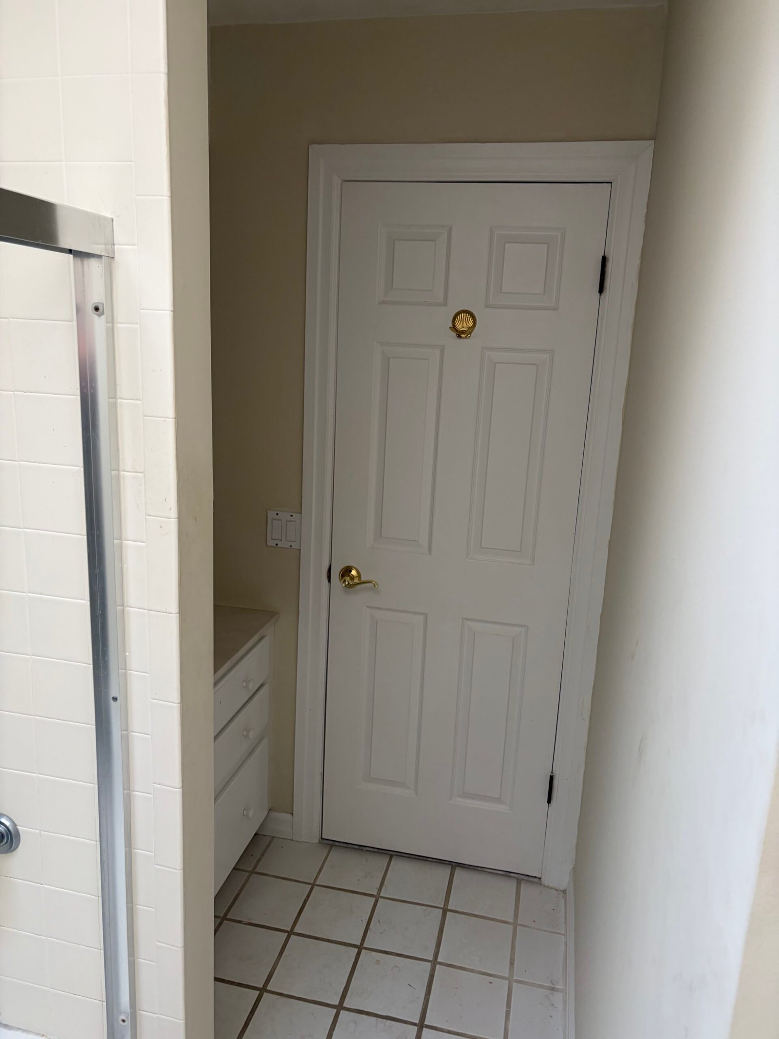 Before: the original bathroom passage, white door and square floor tile.