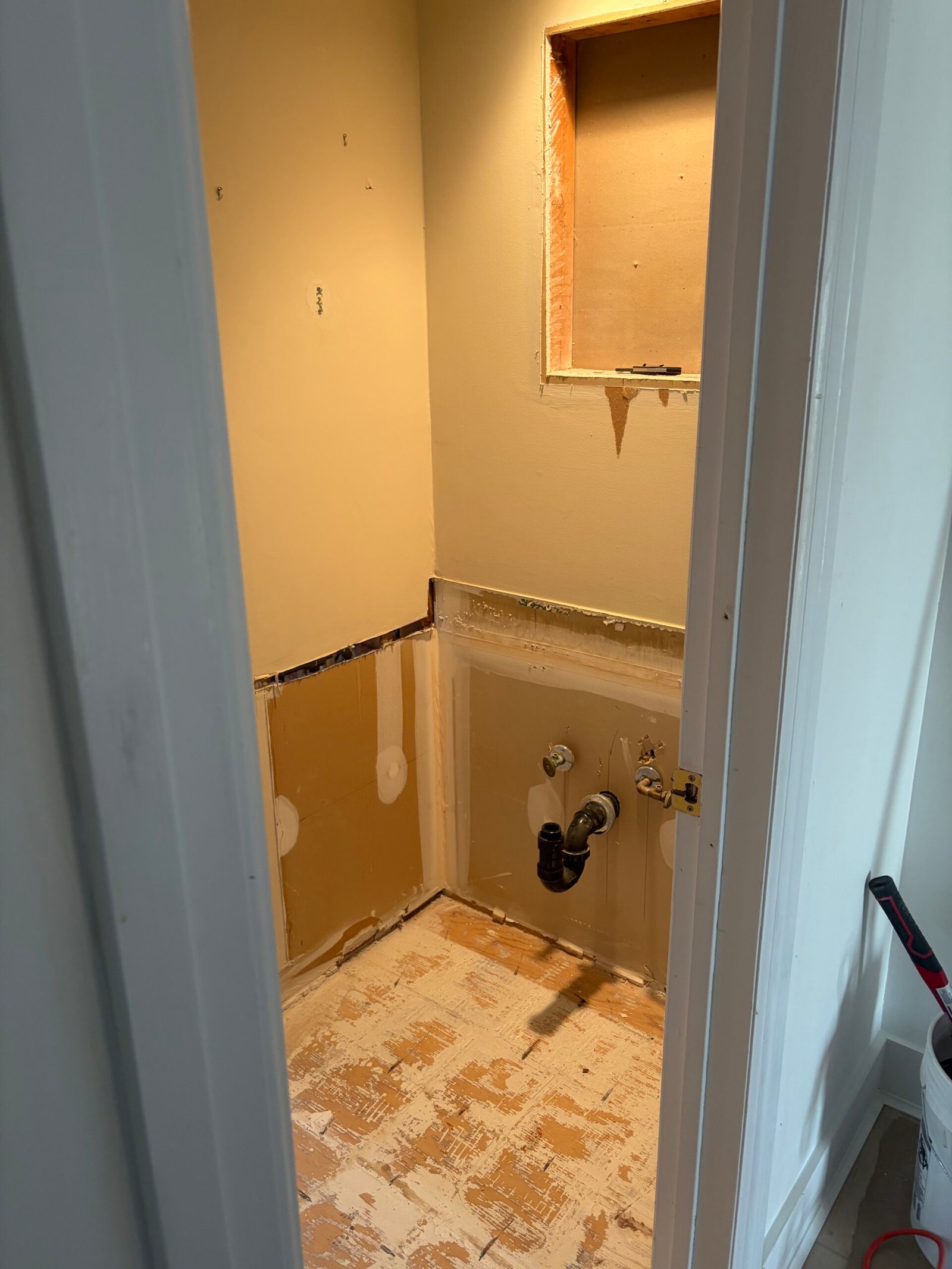 The vanity removed, with the existing supply and drain locations exposed.
