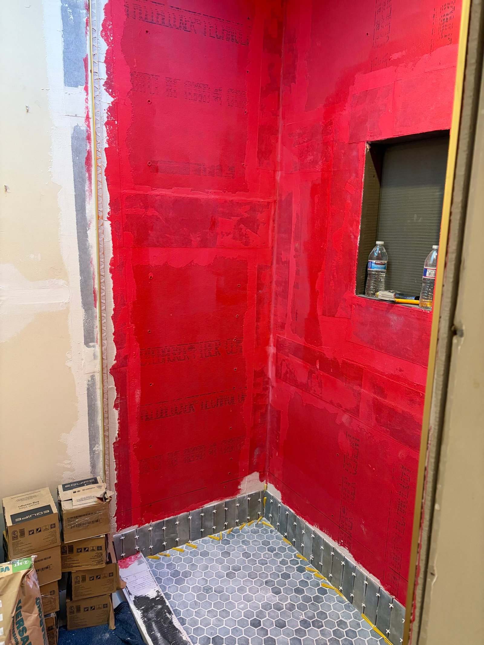 Hexagonal shower-floor mosaic, a recessed niche and coated shower walls.