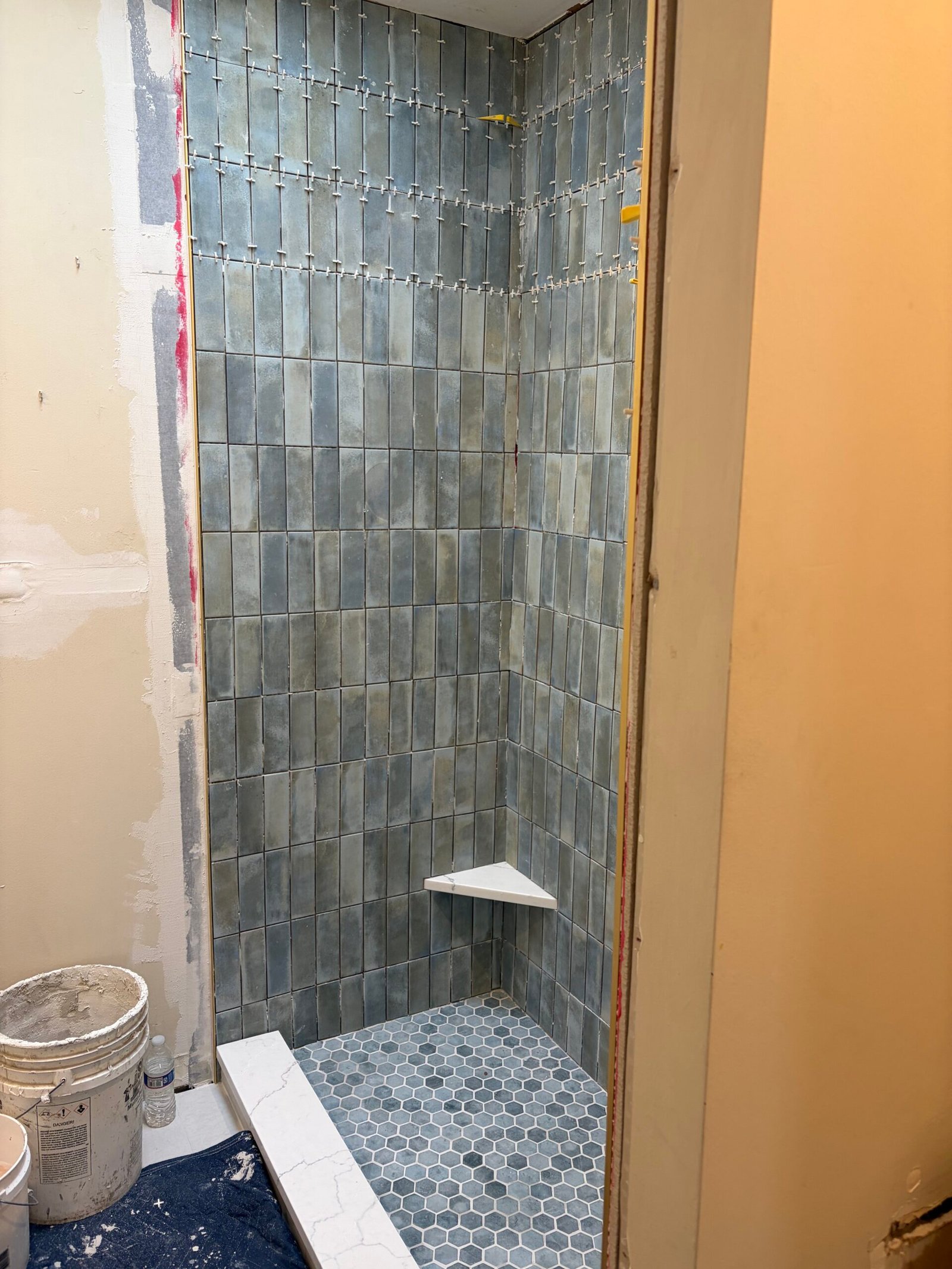 The shower tile extending to the opening while installation is still underway.