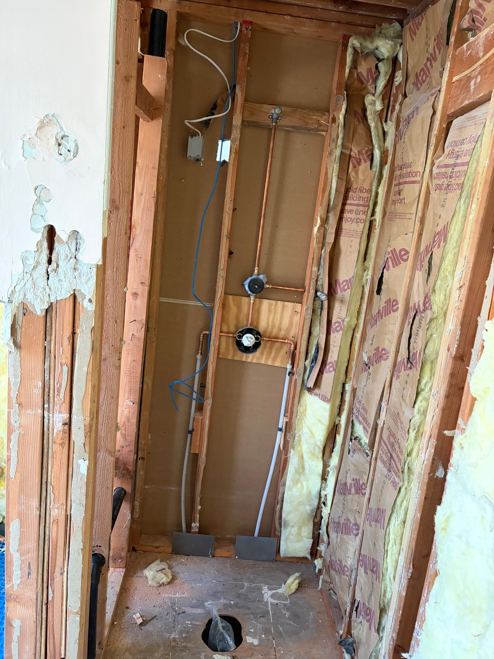 Exposed plumbing and wall framing before the new surfaces were closed in.