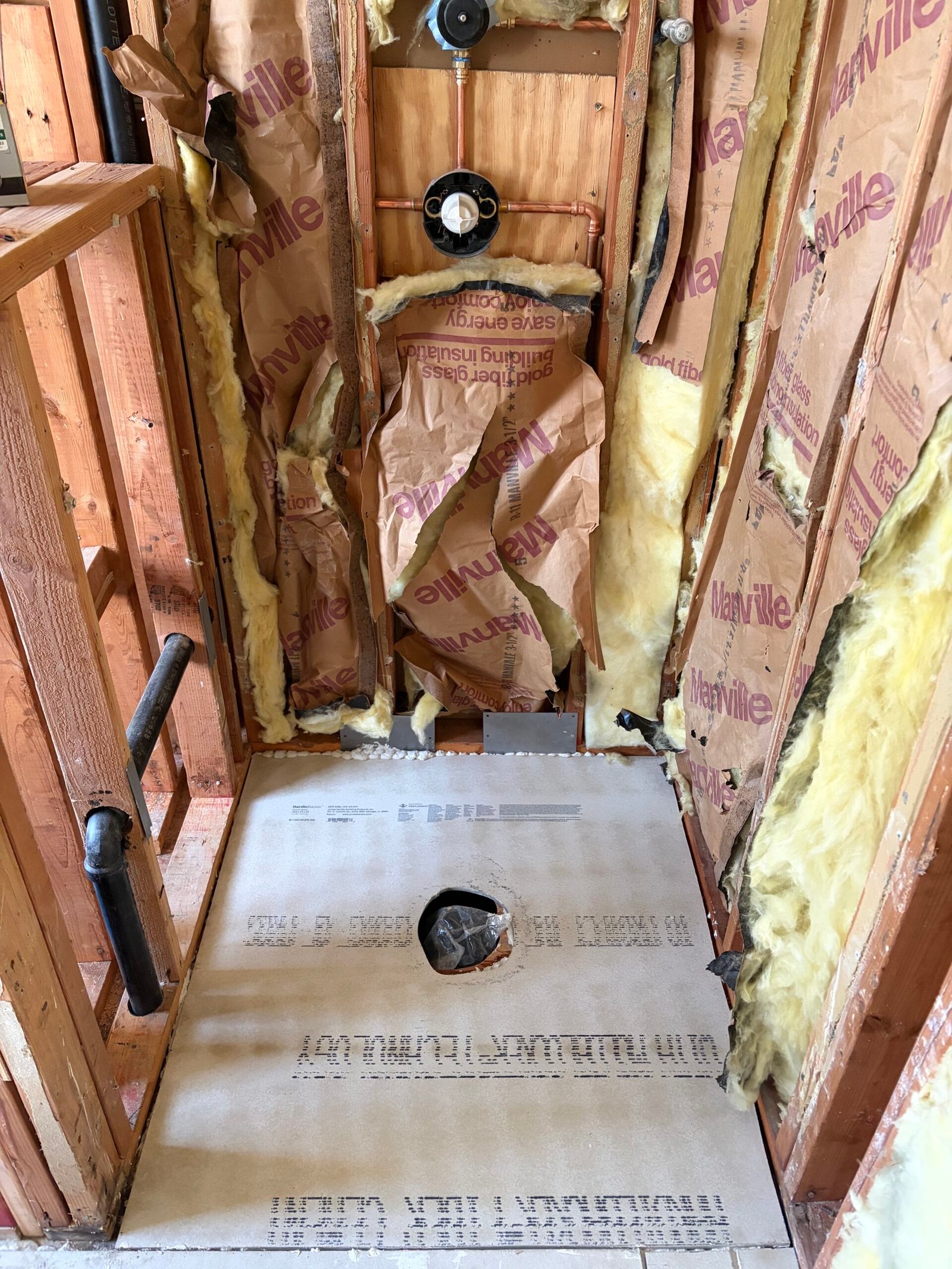 Prepared subfloor and shower plumbing during the rebuild.