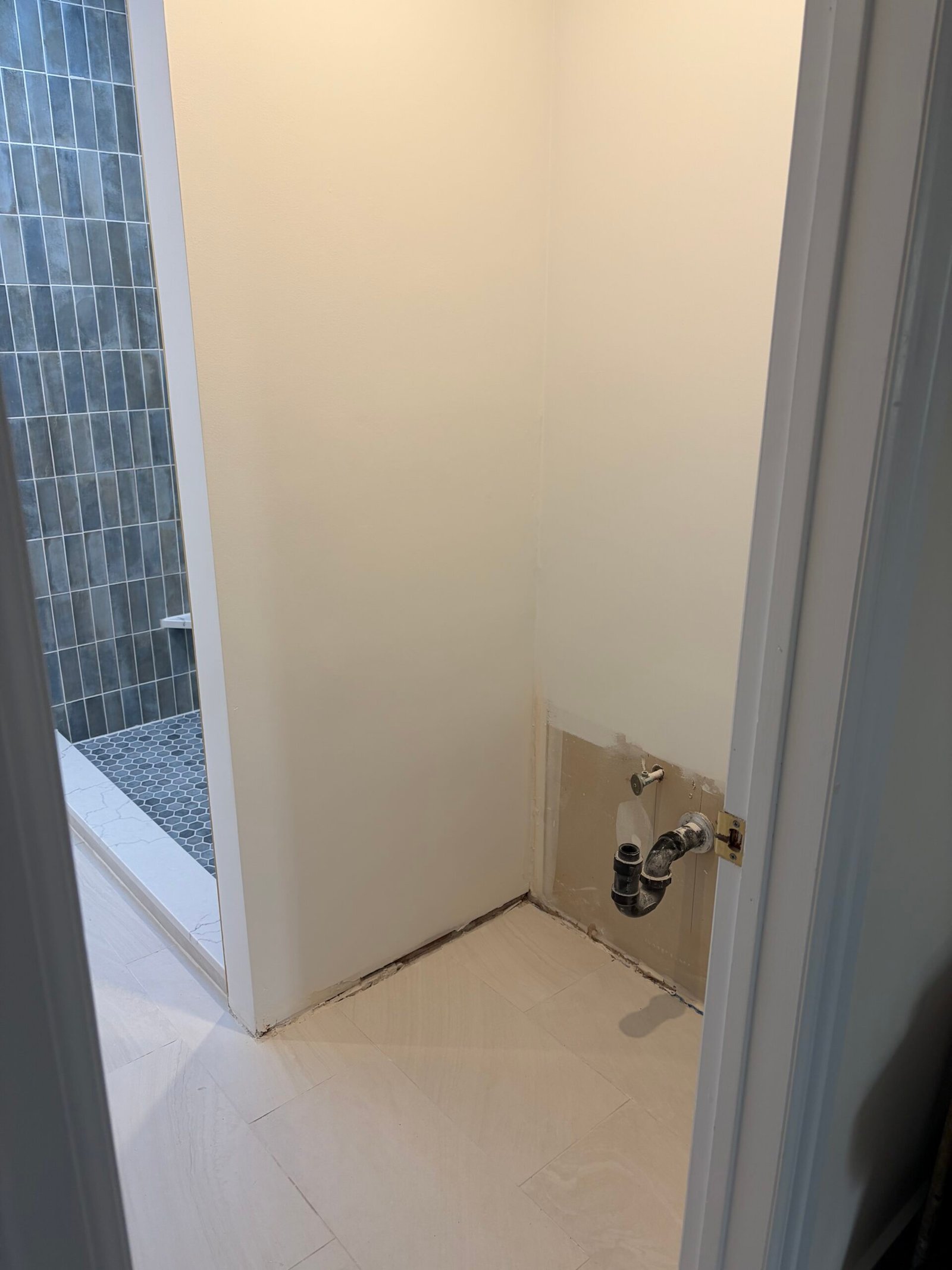 New floor tile and painted walls around the former vanity position.