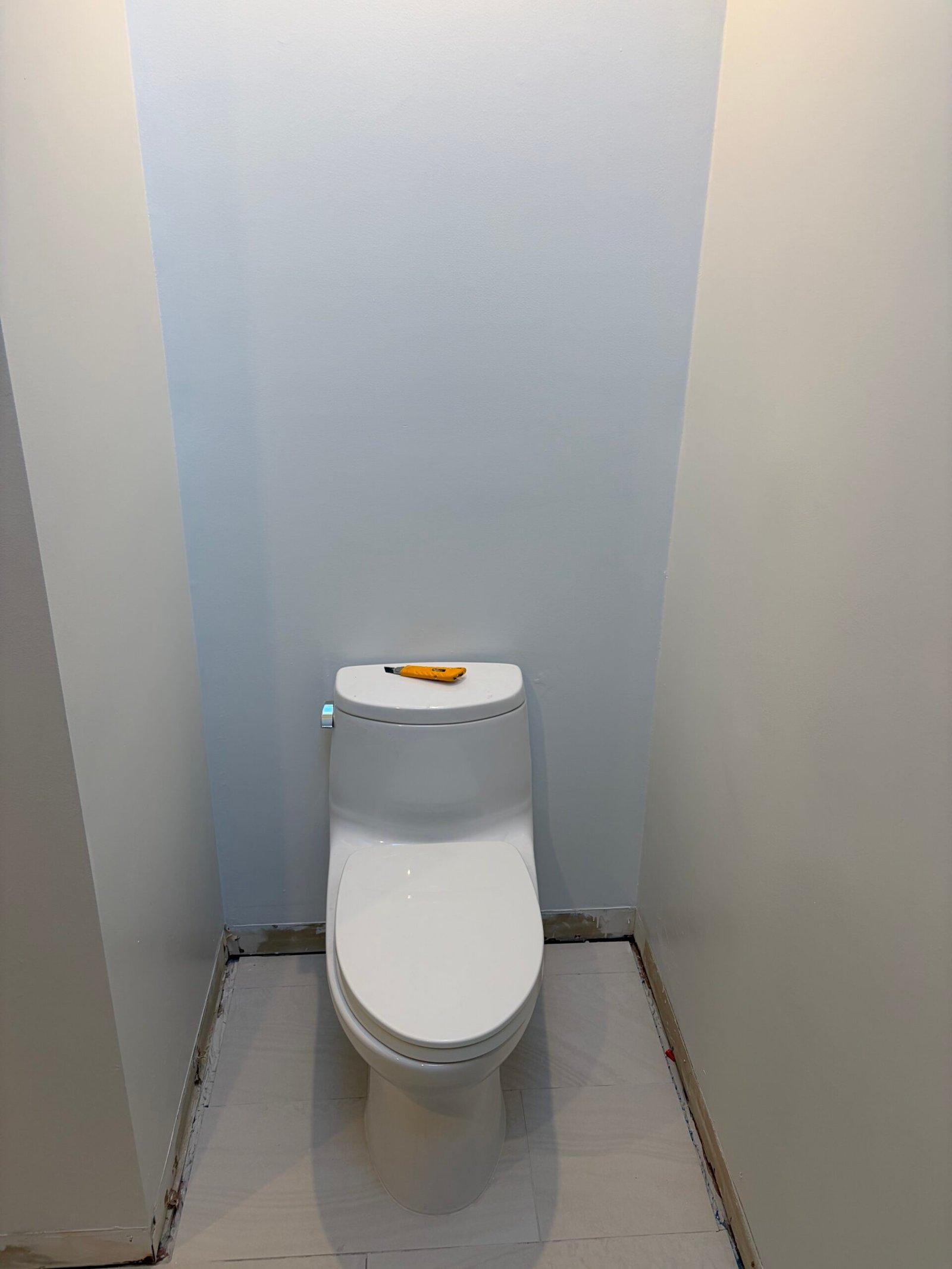 The updated toilet positioned in the alcove before the final trim work.