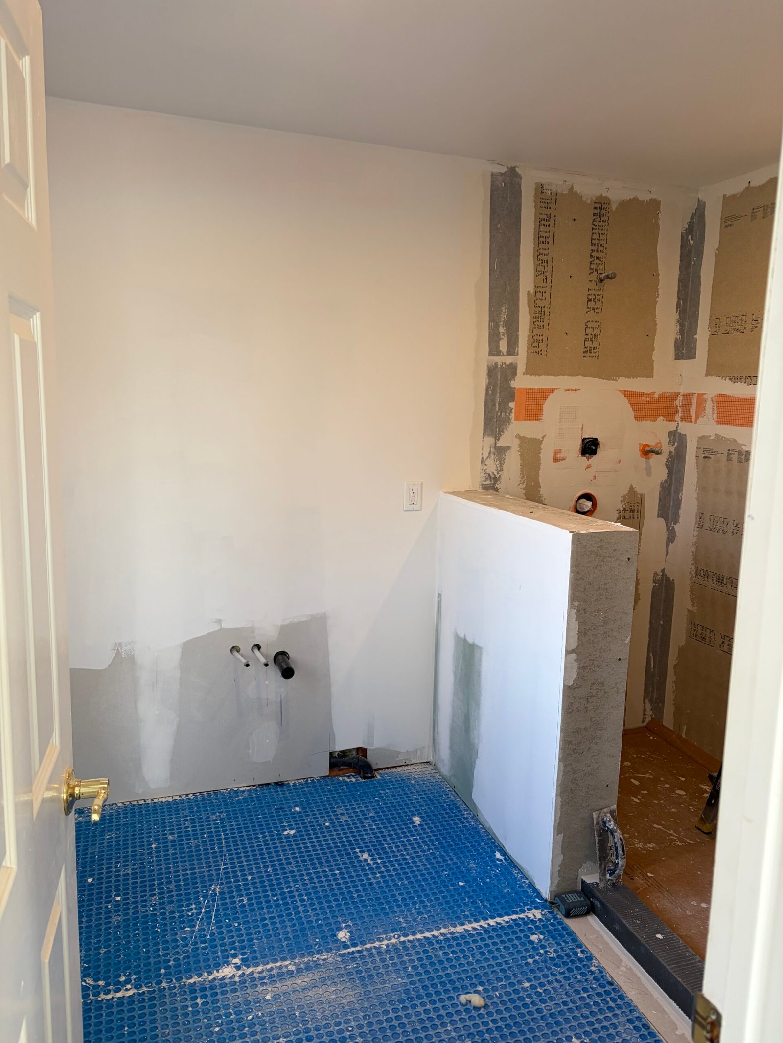 New wall surfaces, floor underlayment and the shower partition taking shape.