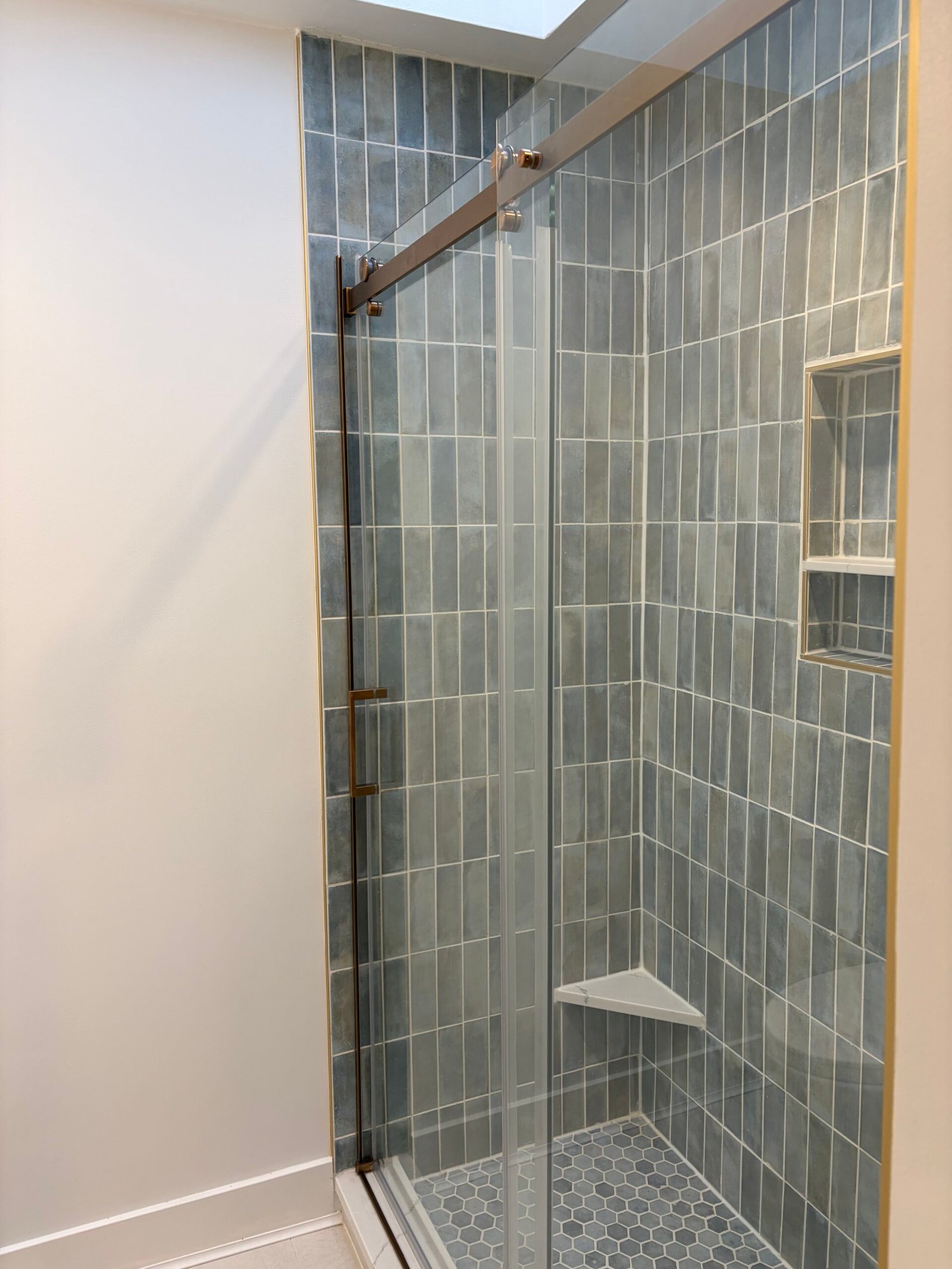 After: the finished shower enclosure and adjoining wall from the bathroom passage.