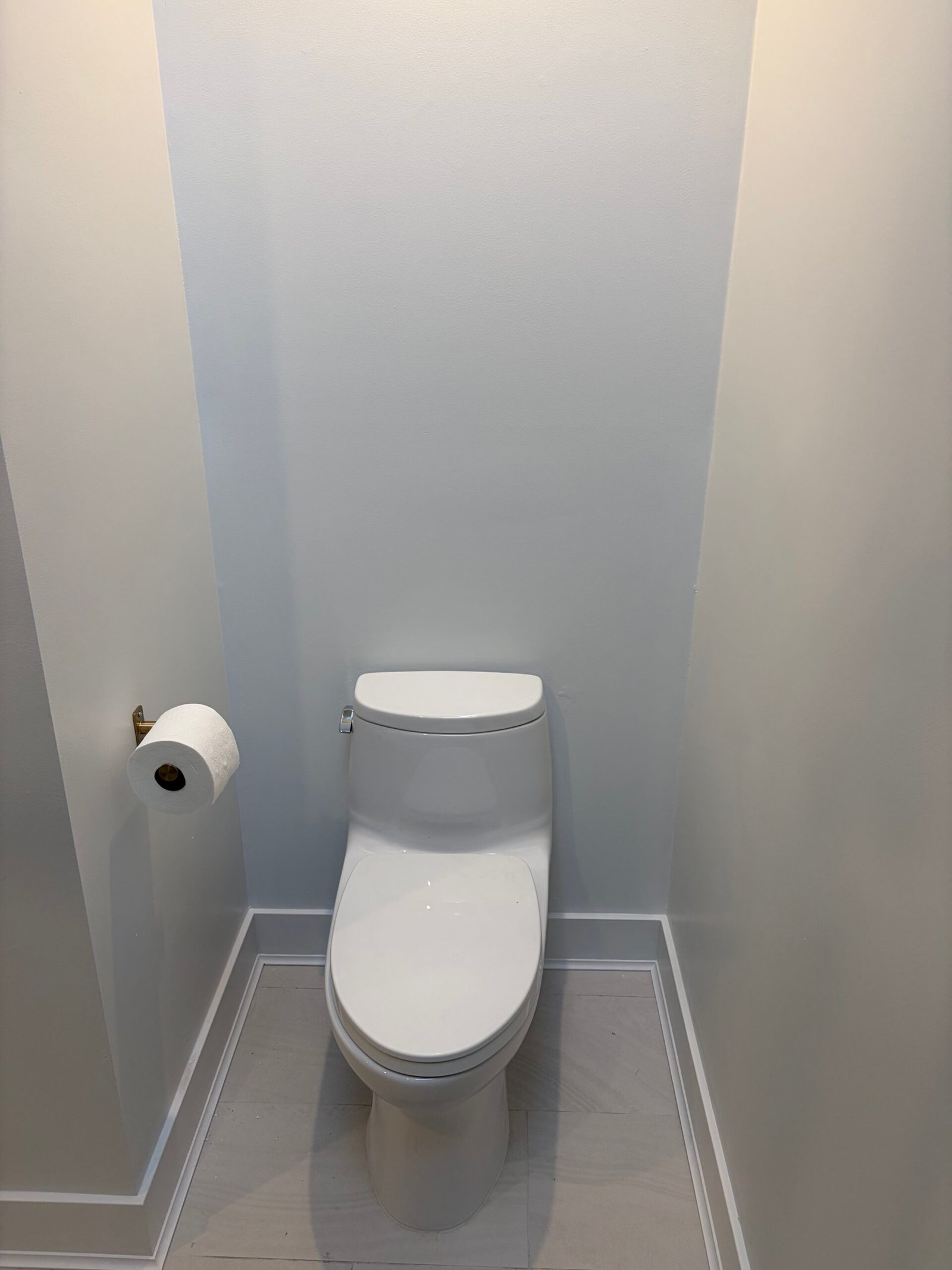 After: the updated toilet alcove with light tile, painted walls and white trim.