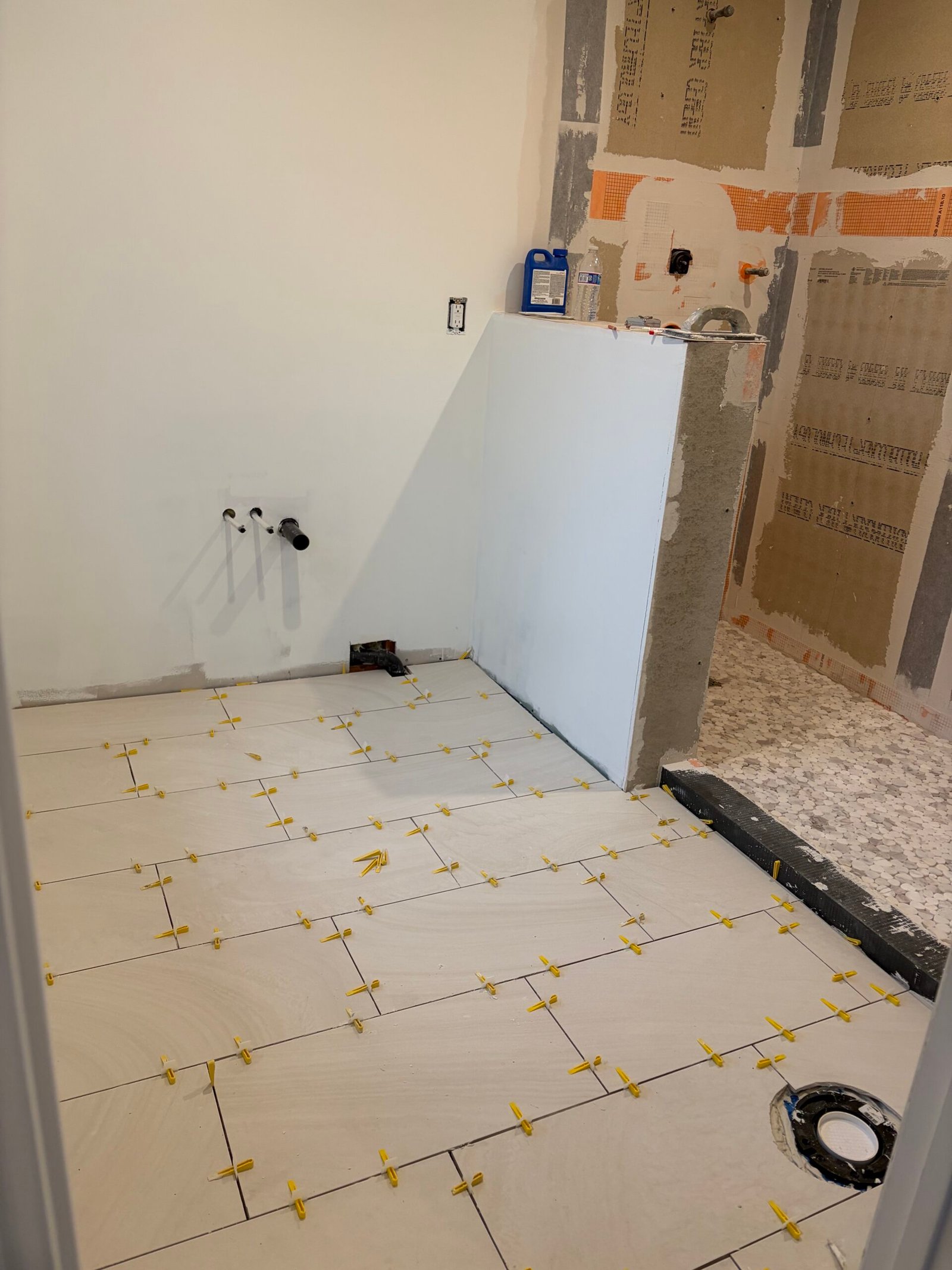 The new bathroom floor tile meeting the walk-in shower area.