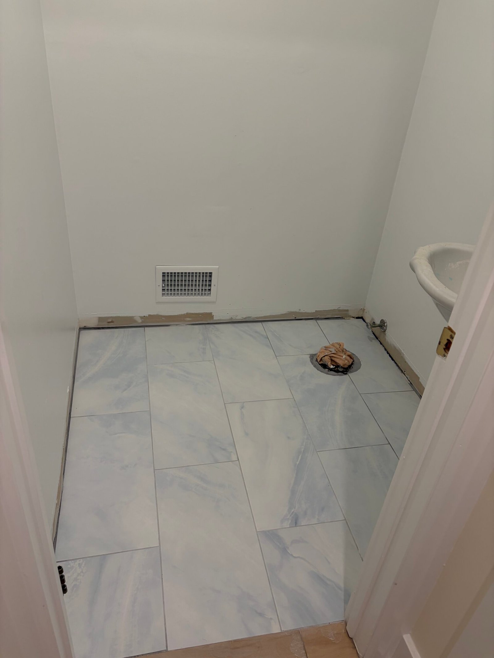 The new floor tile after the installation clips were removed, before the fixtures and baseboards were fitted.